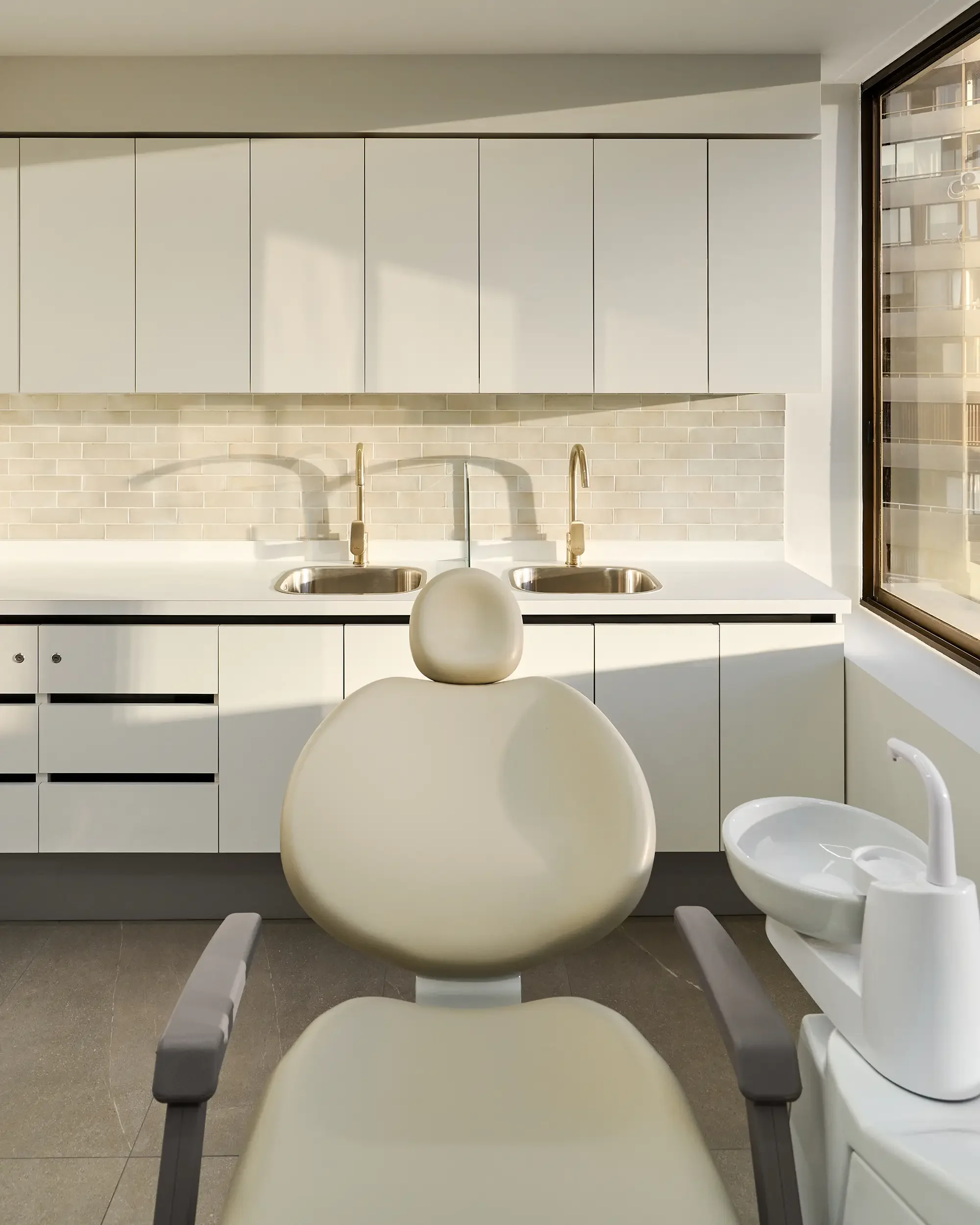 Sillón de dentista en Clínica Aires, una clínica dental moderna en Providencia con equipamiento dental y ventanas grandes que dejan entrar luz natural.