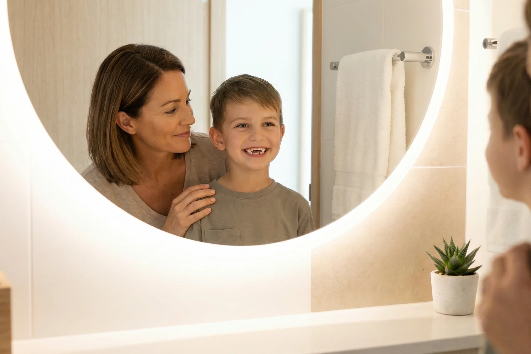 Niño con mordida abierta anterior junto su madre en un baño con espejo redondo