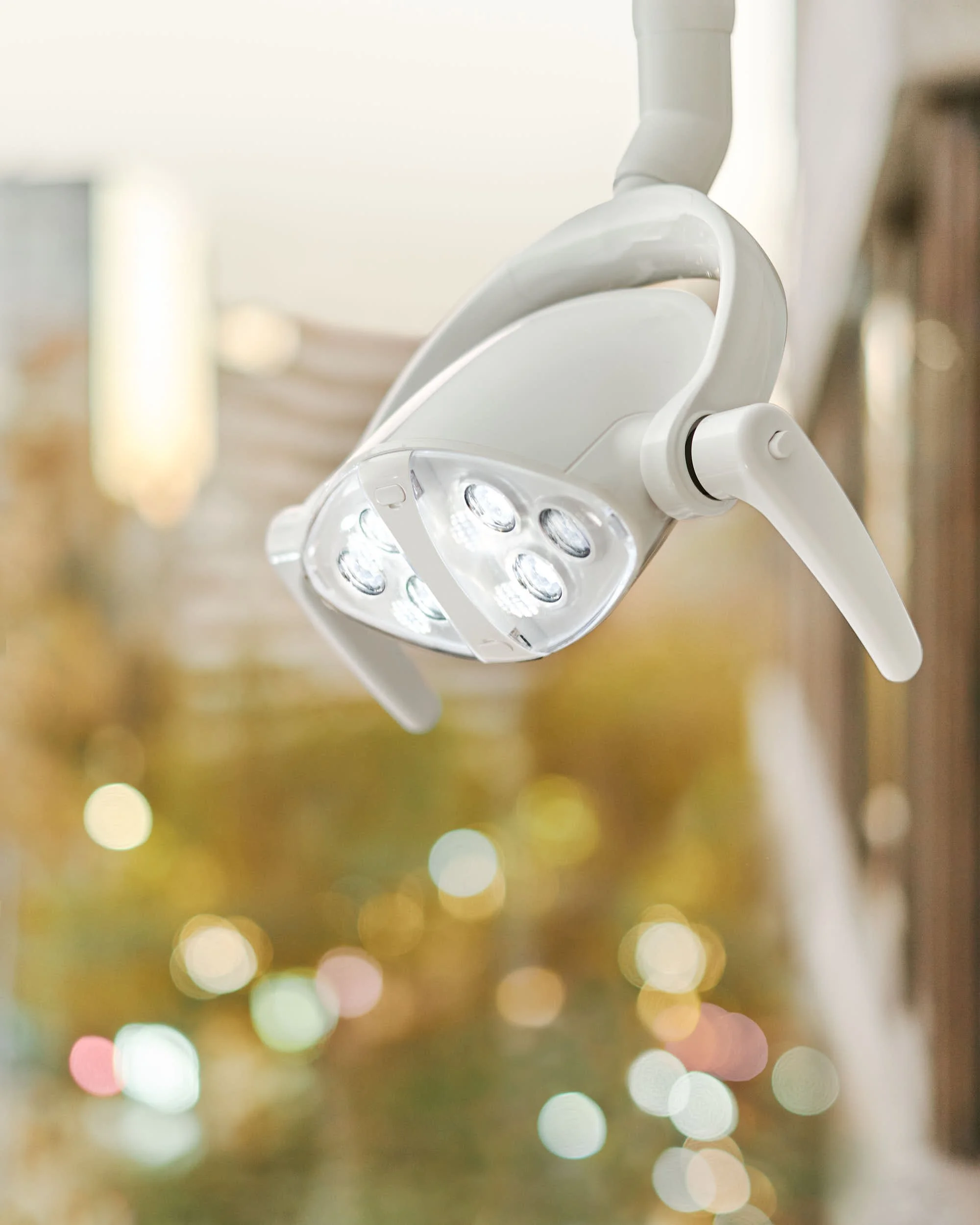 Lámpara de sillón dental en una clínica moderna en Providencia, con ventanas que dejan ver la ciudad.