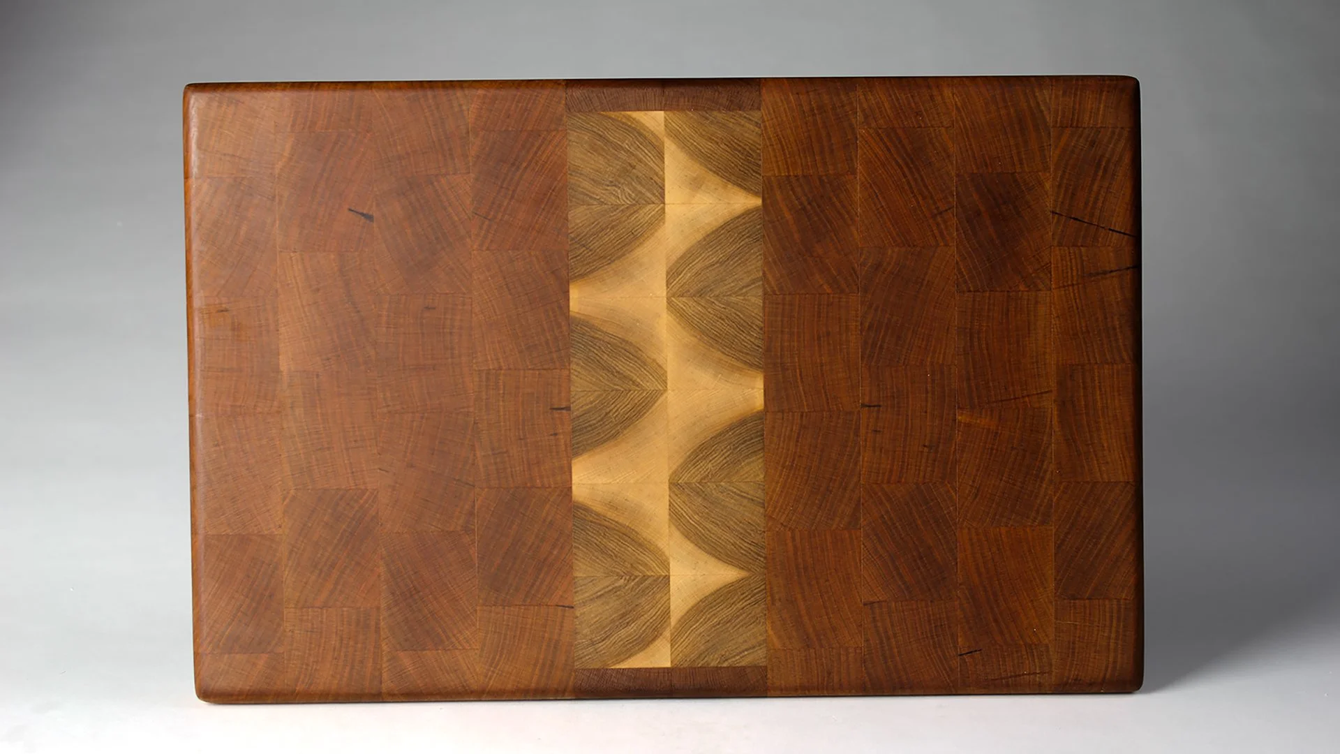 Handmade Cherry and maple end-grain cutting board made by Toryn Black Design, featuring contemporary design and the natural beauty of Appalachian hardwoods. Crafted in Western North Carolina, this distinctive wooden serving board is designed for ever
