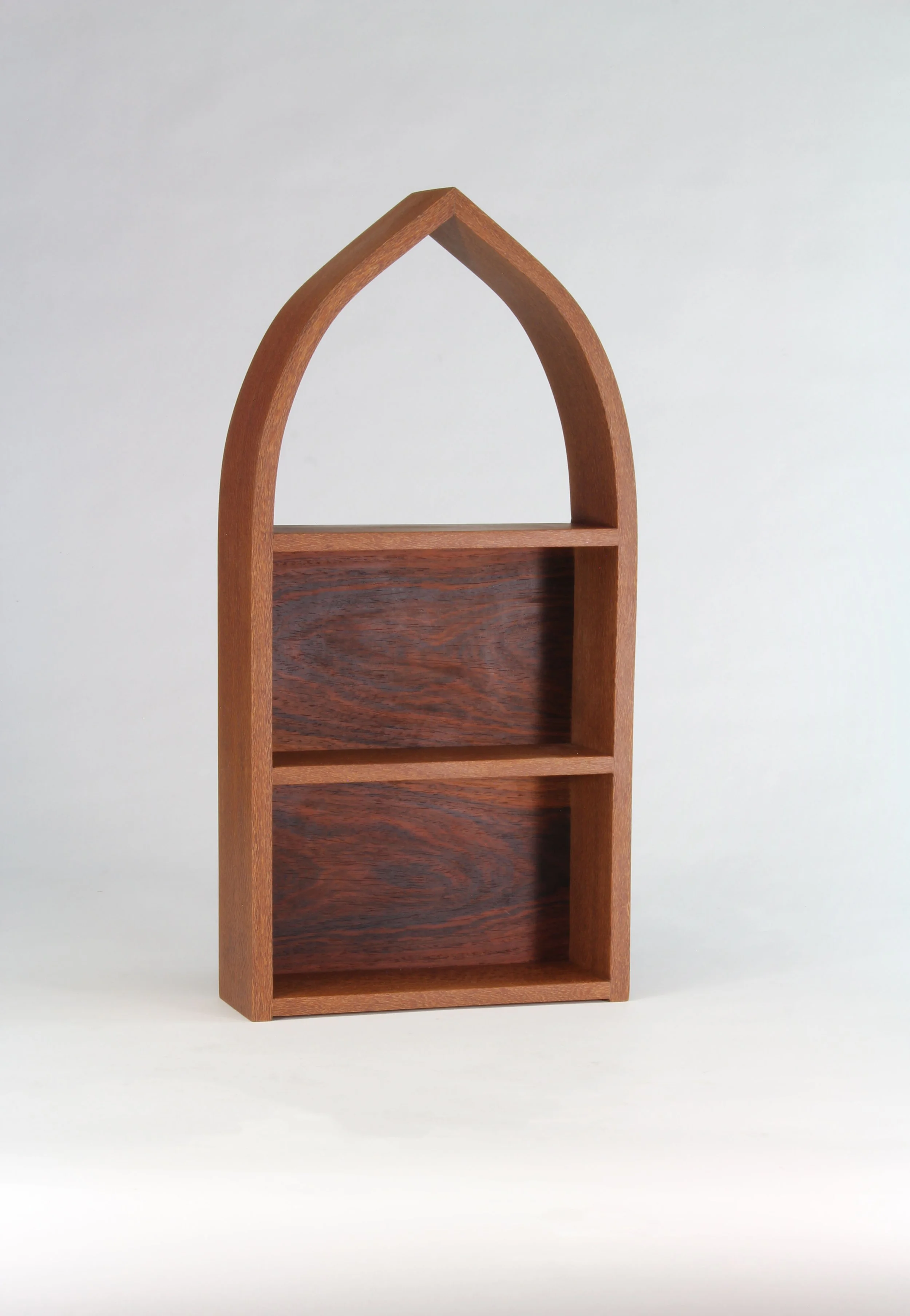 Handcrafted small arch-shaped wall shelf by Toryn Black Design, made from distinctive leopardwood with rosewood veneer accents. Featuring a sculptural architectural form and rich natural wood grain, this contemporary decorative shelf showcases fine w