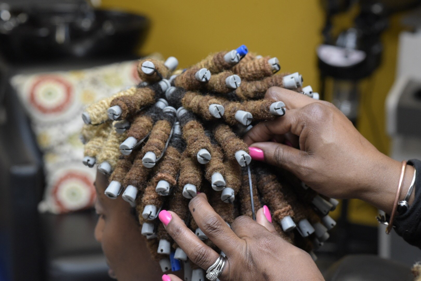 Loctician putting in pipecleaners as a loc style