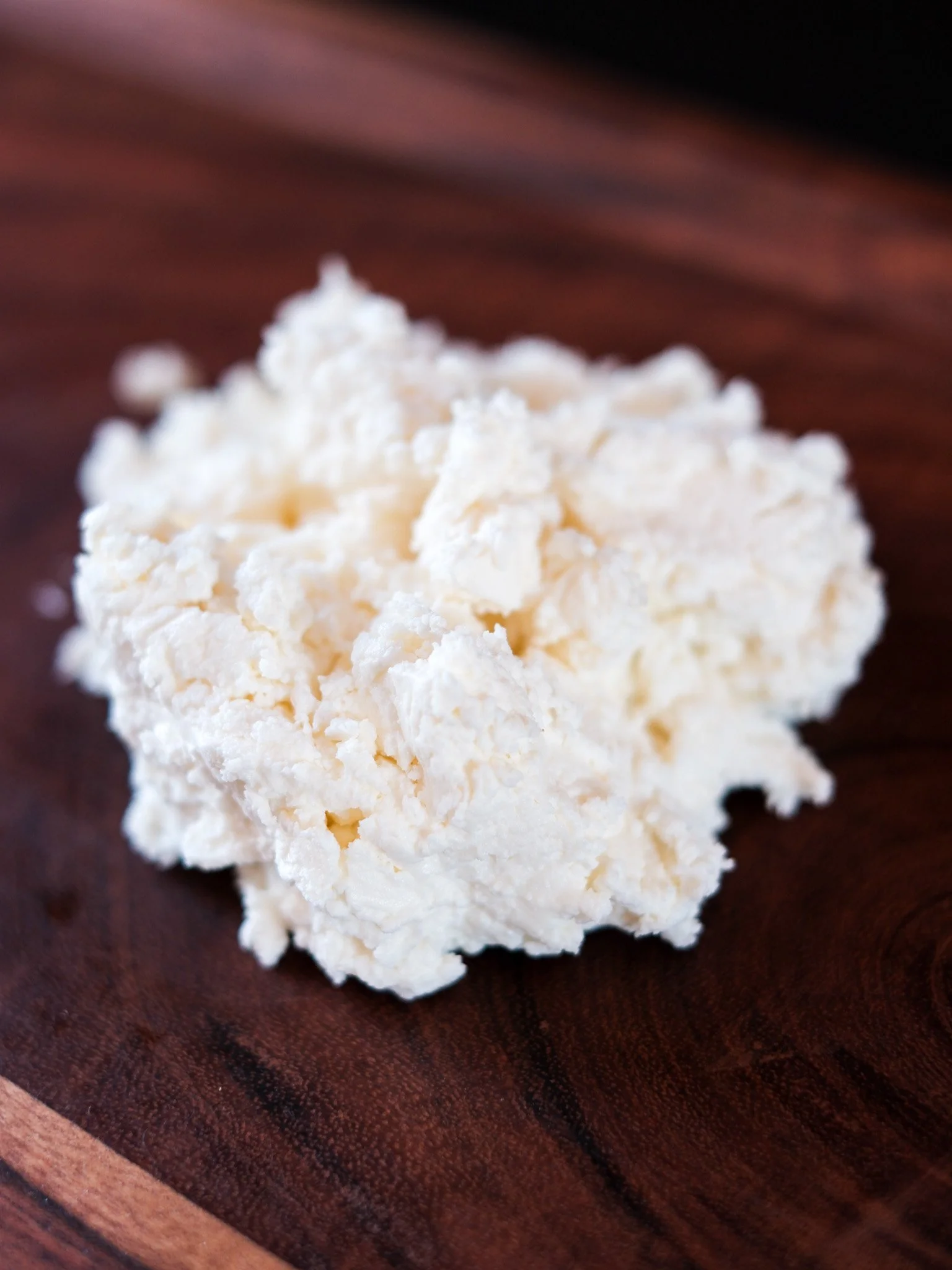 a piece of fresh chevre by laura chenel on a cutting board