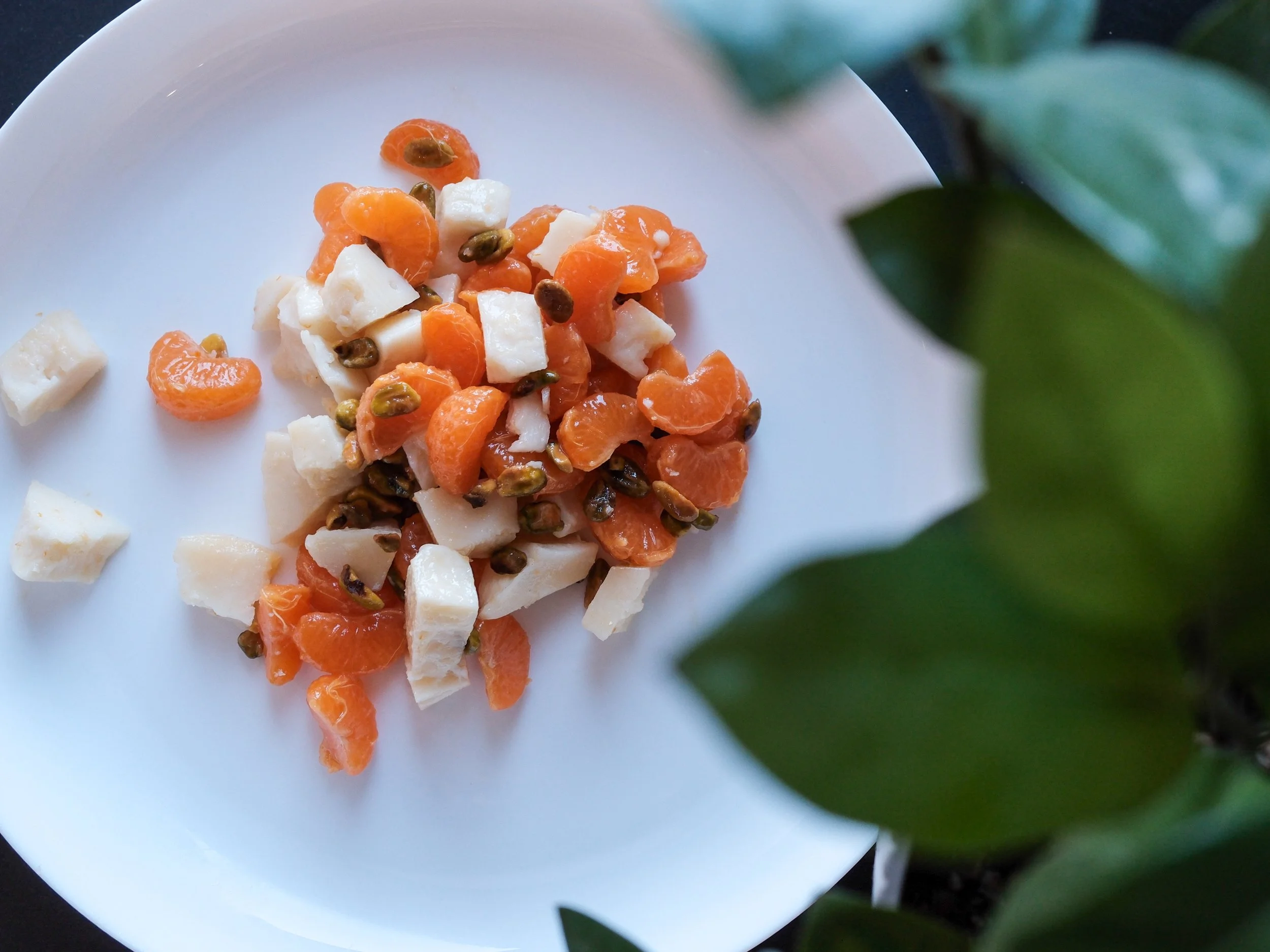 a beautiful salad plate with mandarins, pistachios, and sheep's milk cheese.
