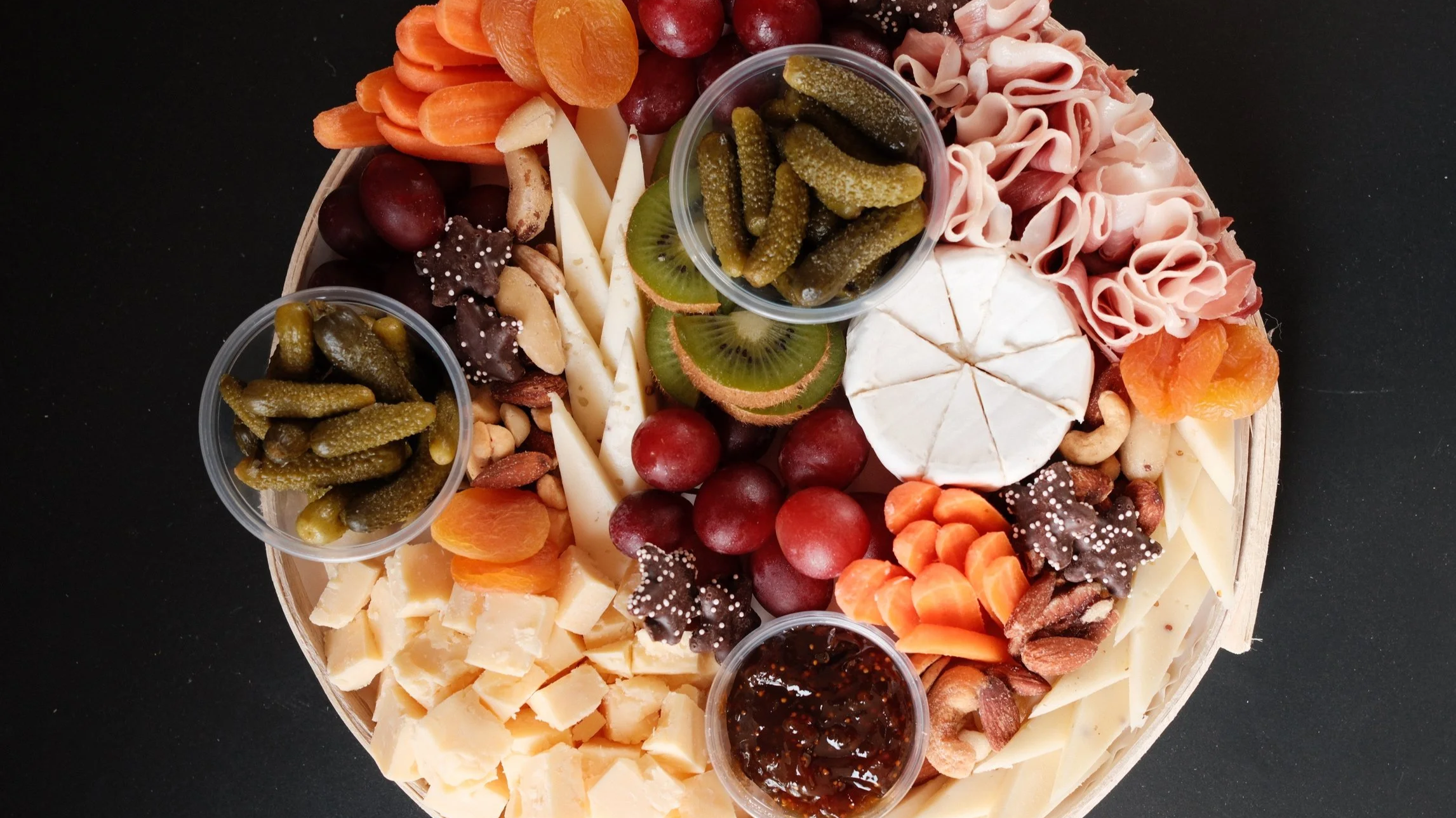 Small grazing - charcuterie board filled iwth meat cheese fruit nuts pickles and jam