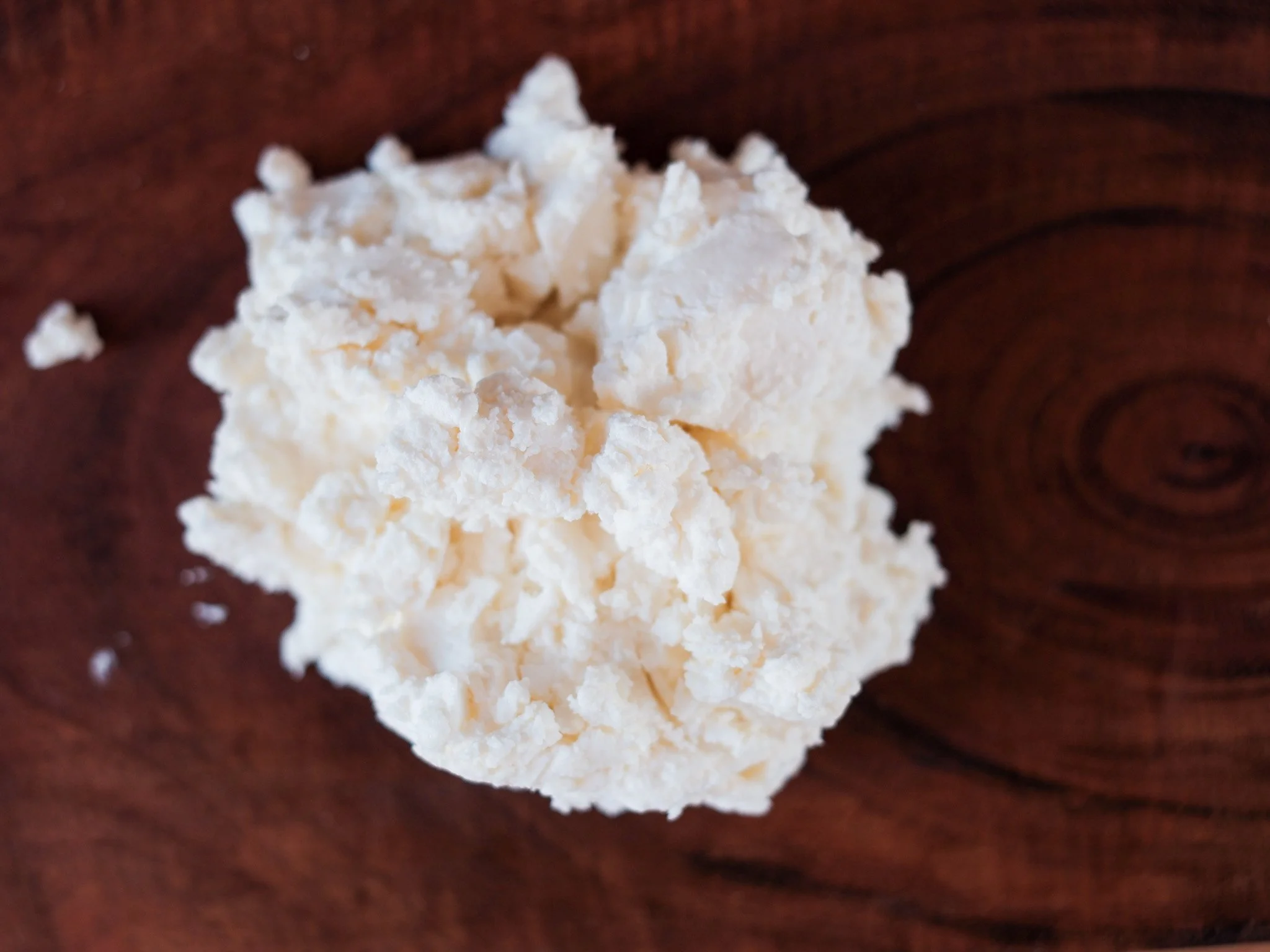 a pile of fresh fromage blanc by stepladder creamery sits on a wooden board