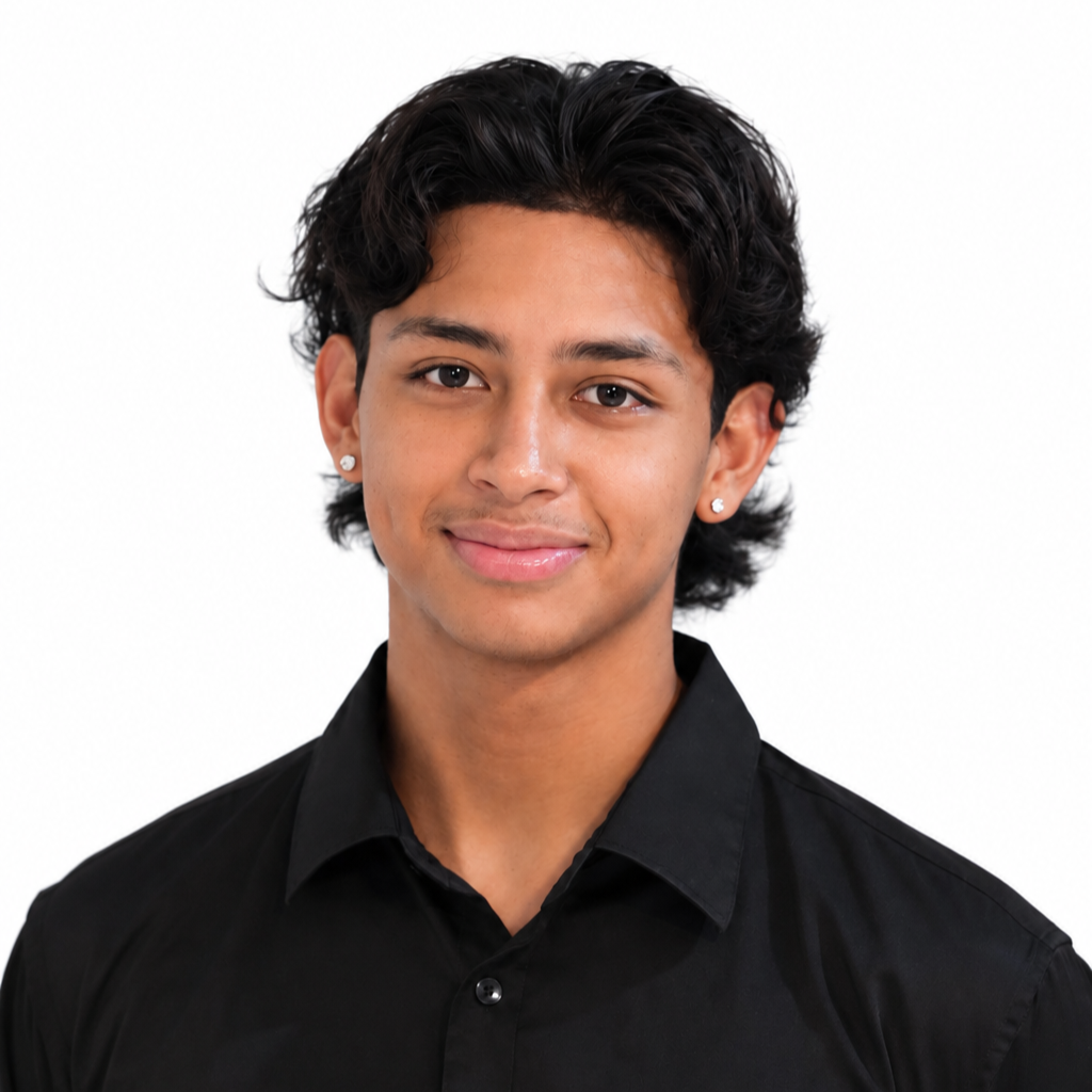 A young man with black, wavy hair, light brown skin, wearing a black shirt and earrings, smiling slightly, against a white background.