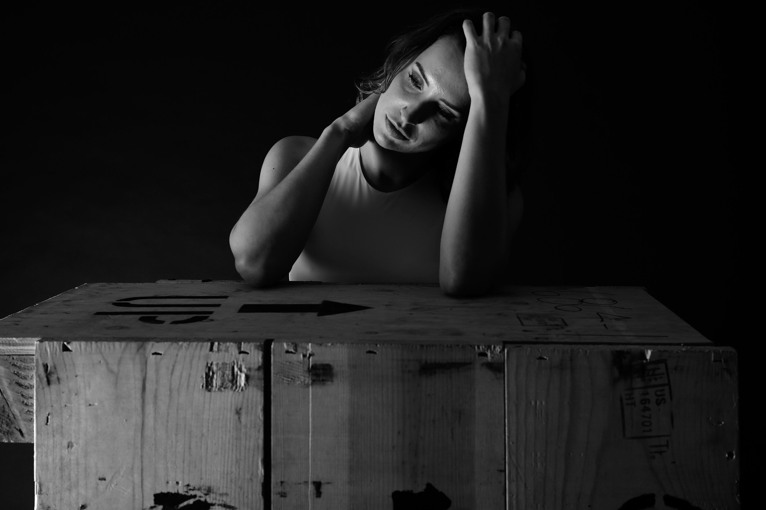 woman leaning on box looking frustrated