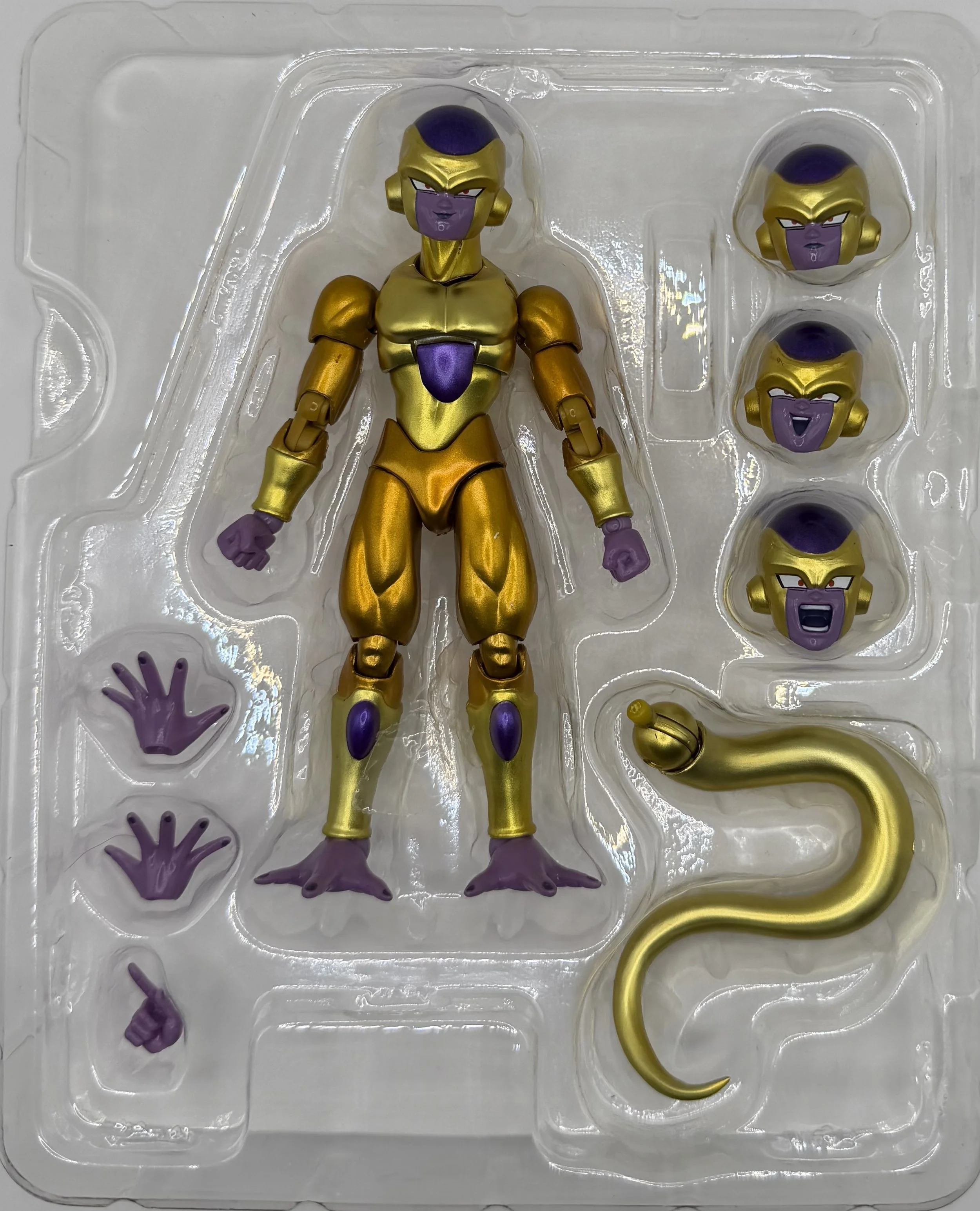 A collectible action figure of Frieza from Dragon Ball Z, with interchangeable heads displaying different facial expressions, located in clear plastic packaging.