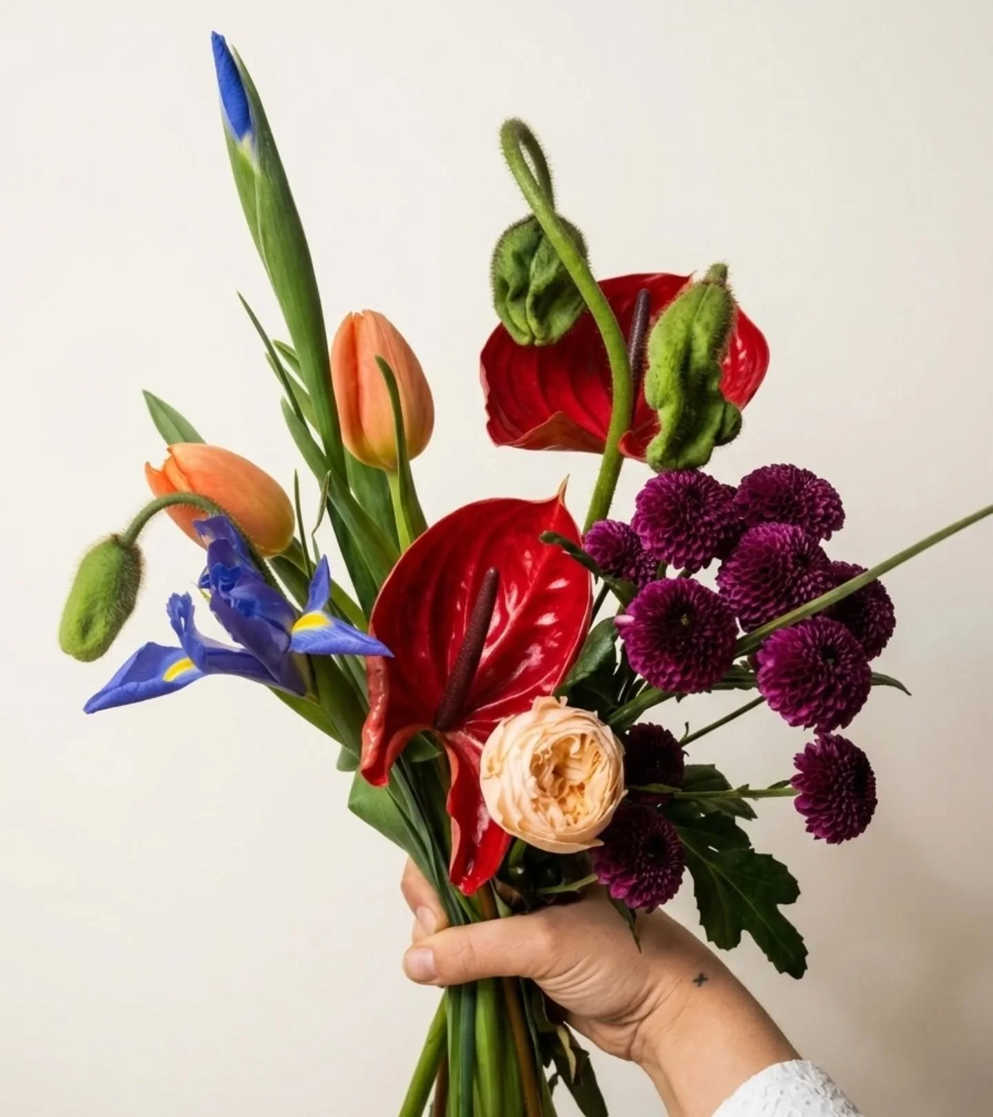Texture on texture. ✨ There is something so rewarding about a palette that feels both electric and grounded. From the waxy gloss of the Anthurium to the delicate, crinkled paper petals of the Iceland Poppy, this arrangement is all about the details.
