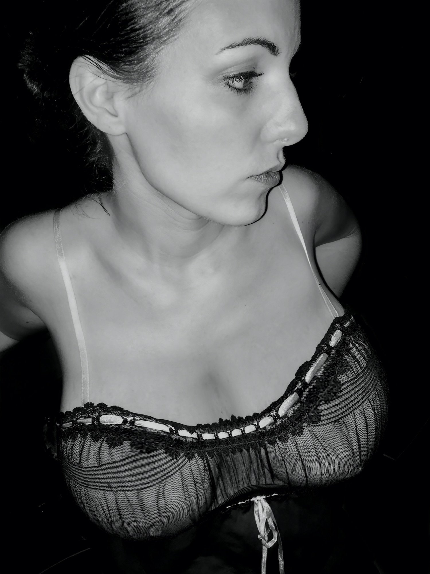 Le modèle, capturé de profil, révèle une beauté naturelle et une sensualité subtile à travers une lingerie en dentelle délicate mettant en valeur sa lourde poitrine aux courbes généreuses. Nathalie Quiers photographiée par Yoann Vareille, photographe