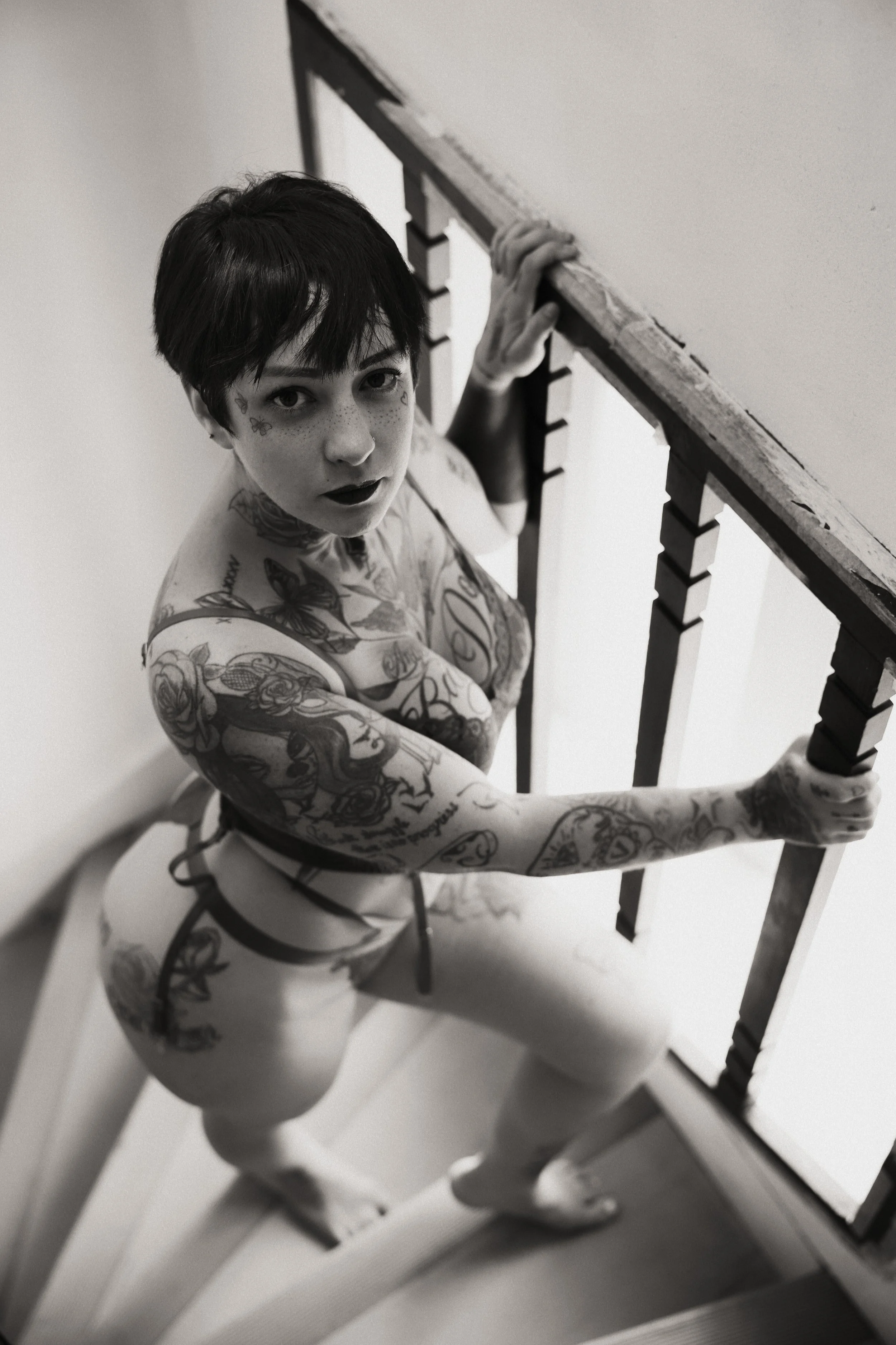 portrait-sexy-lingerie-poitrine-decollete-string-fesses-vue-plongeante-rampe-escalier-regard-camera-noir-et-blanc-anne-gaelle-yoann-vareille-photographie-charme-sensualite-brive-correze-nouvelle-aquitaine.jpg