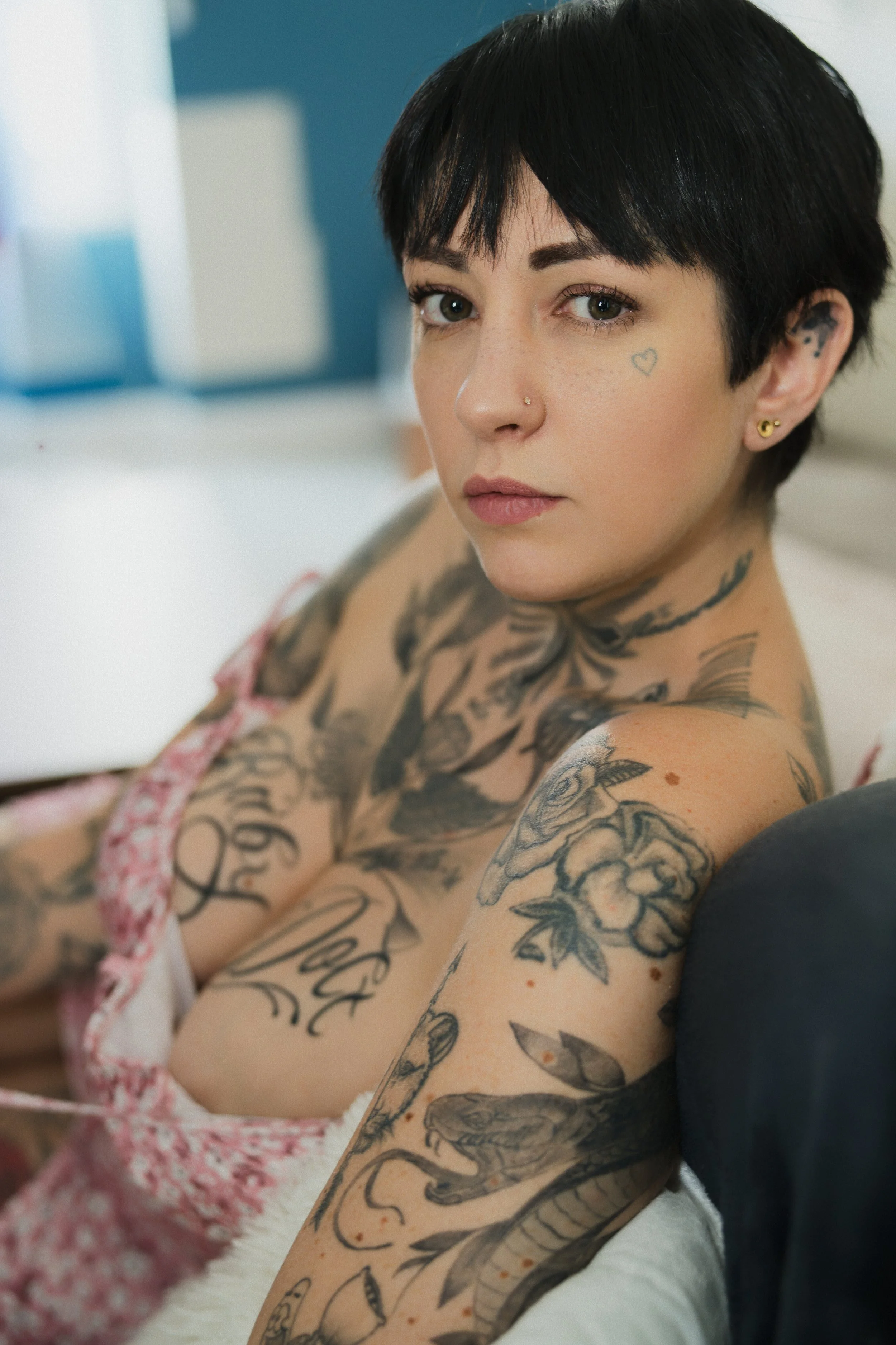 04-portrait-sexy-femme-tatouee-anne-gaelle-canape-robe-rose-poitrine-decollete-regard-camera-yoann-vareille-photographie-charme-sensualite-brive-correze.jpg