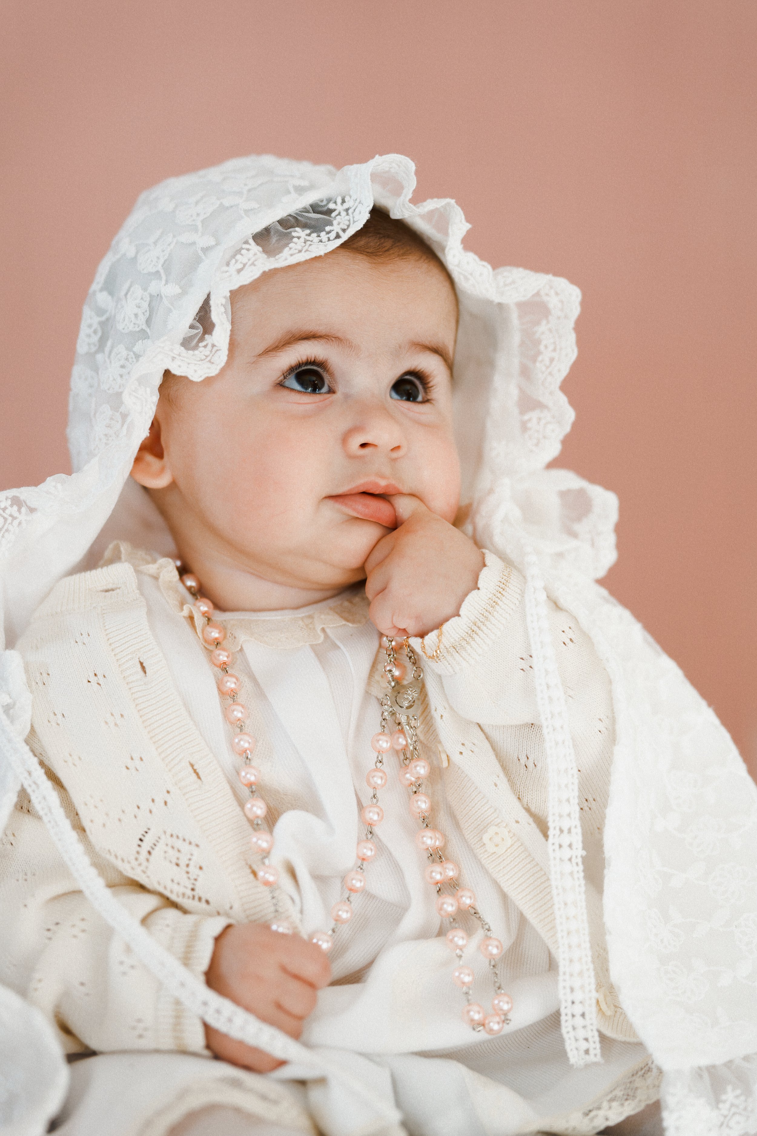 portrait-bebe-bapteme-voile-blanc-chapelet-fond-rose-yoann-vareille-photographe-brive-correze-nouvelle-aquitaine.jpg