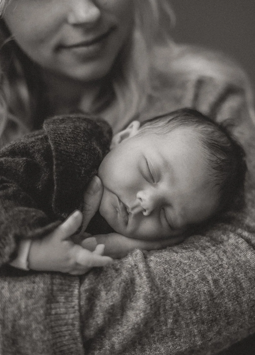 Close-up van een pasgeboren baby in de armen van zijn moeder tijdens een intieme newborn fotoshoot in Utrecht