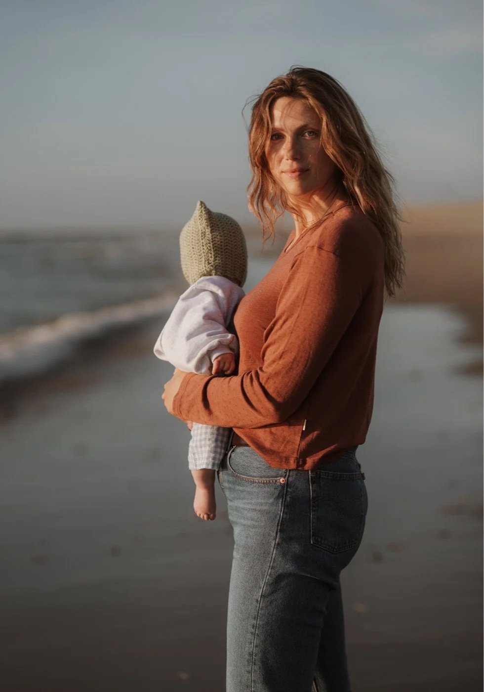 Moeder en baby aan zee in sterk licht