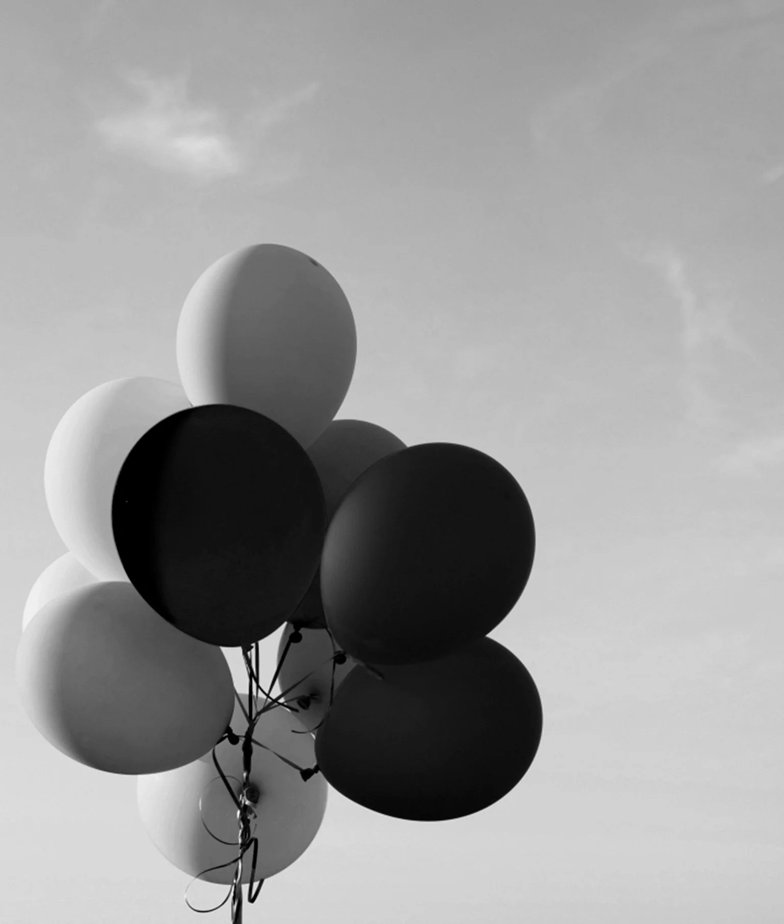 Schwarz-Weiss-Bild von Luftballons am Himmel