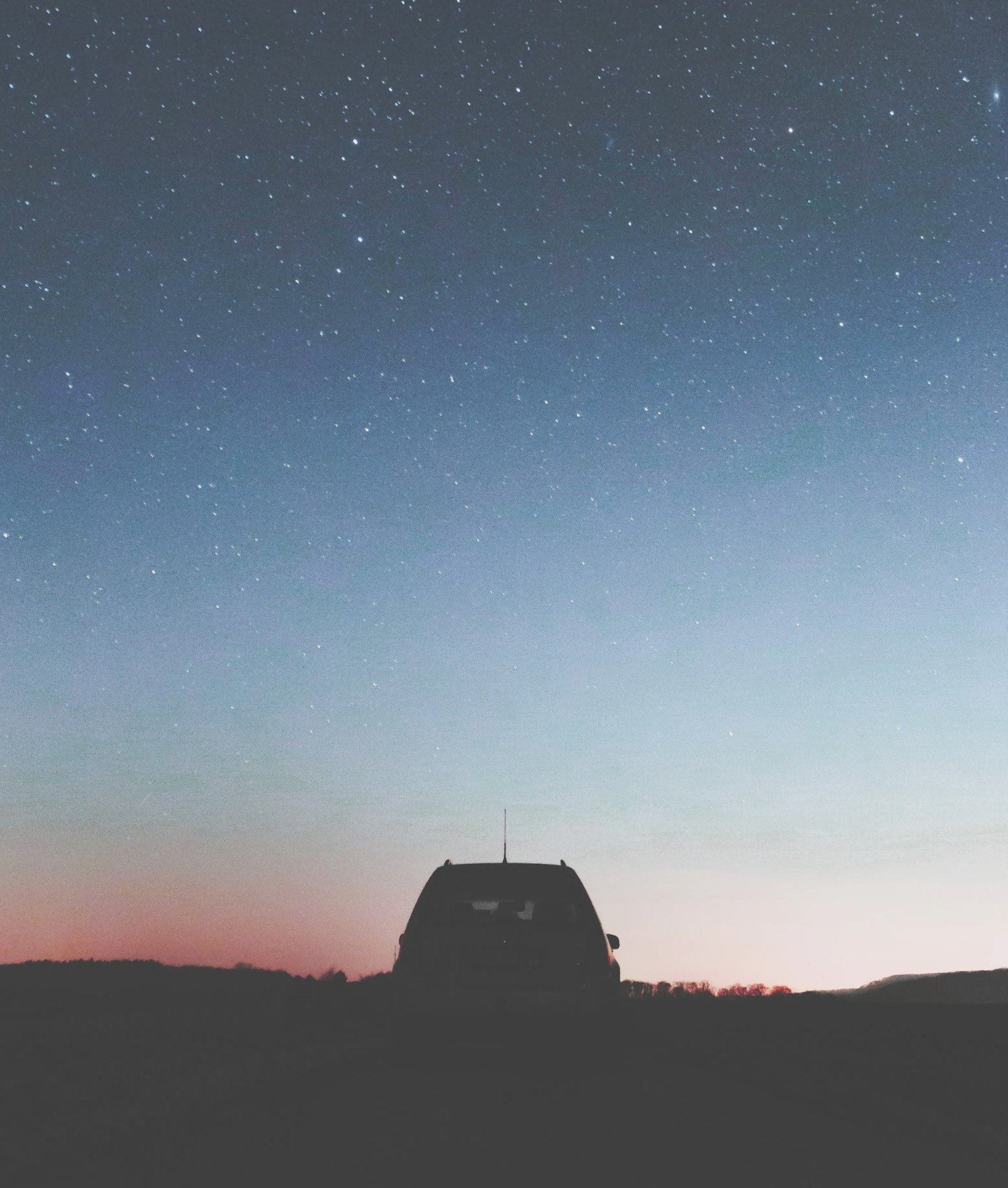 Geparktes Auto vor Sternenhimmel