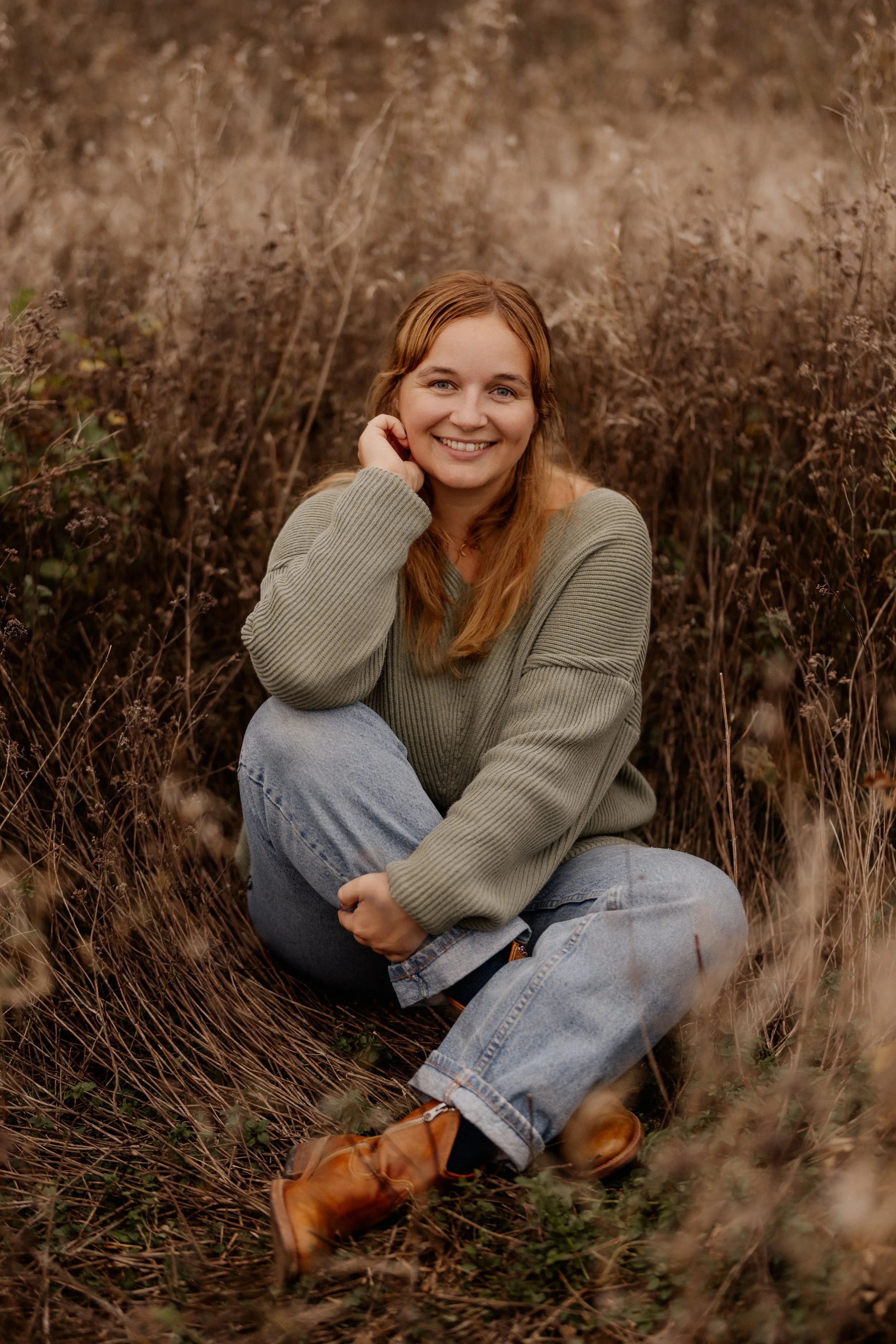 Portrait von Lina, sitzend im Feld. Herbstfarben und -look.