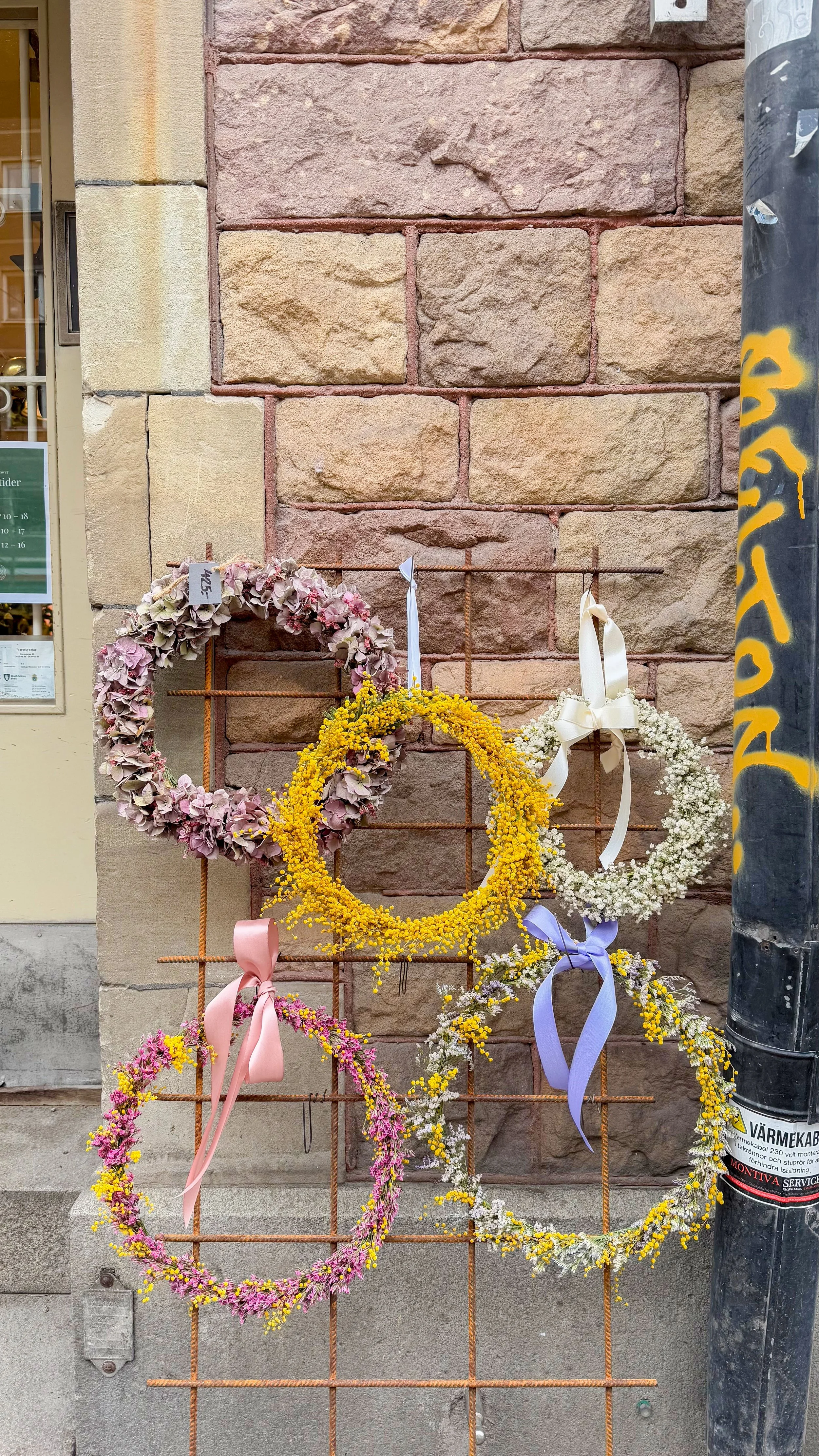 Blumenkränze in vor einer backsteinähnlichen Wand in Stockholm.