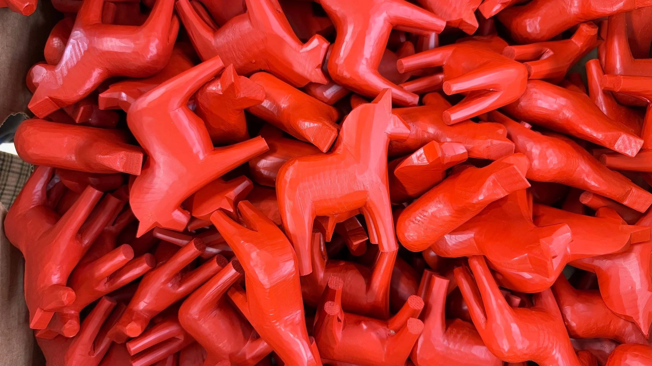 Viele rote Holzpferde in einem Haufen