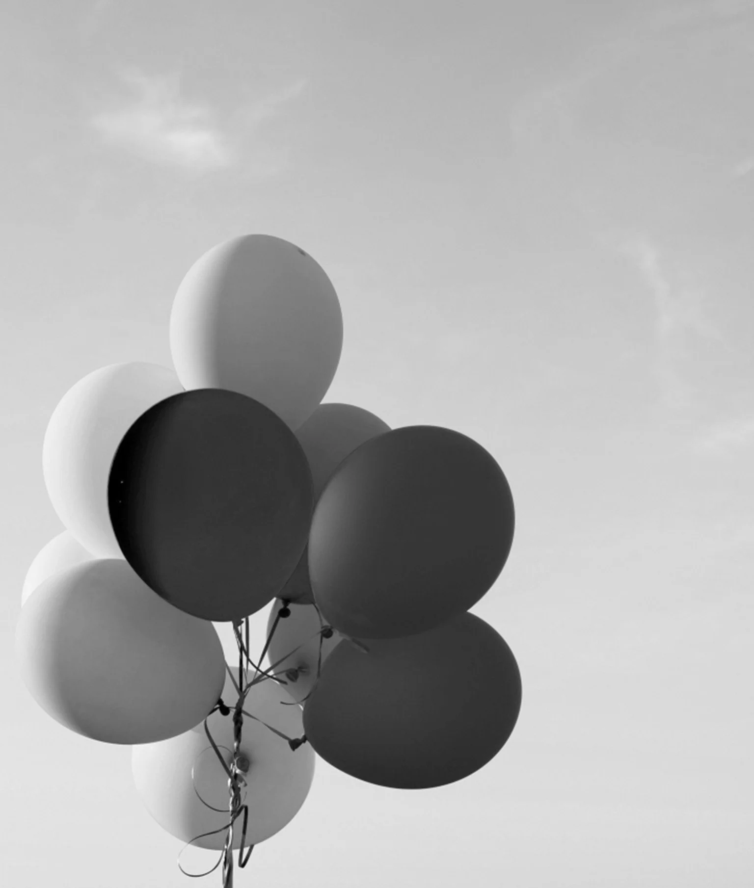 Schwarz-Weiss-Bild von Luftballons am Himmel