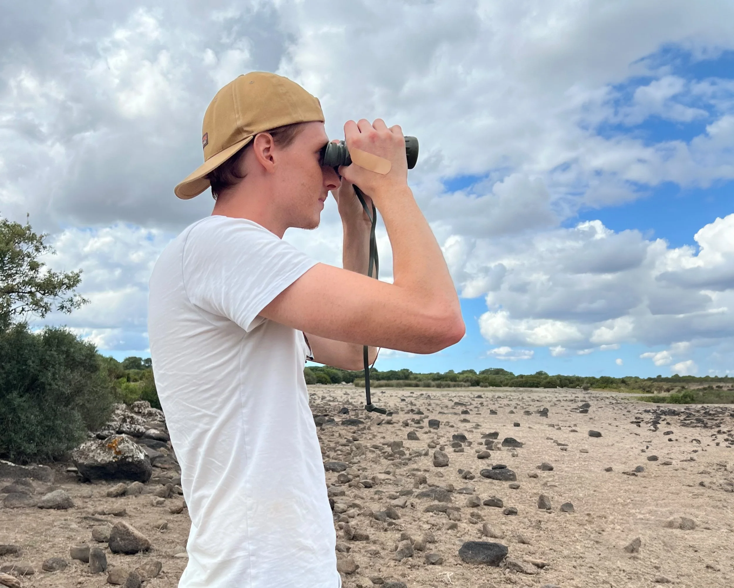 Dario beobachtet Pferde durch seinen Feldstecher.
