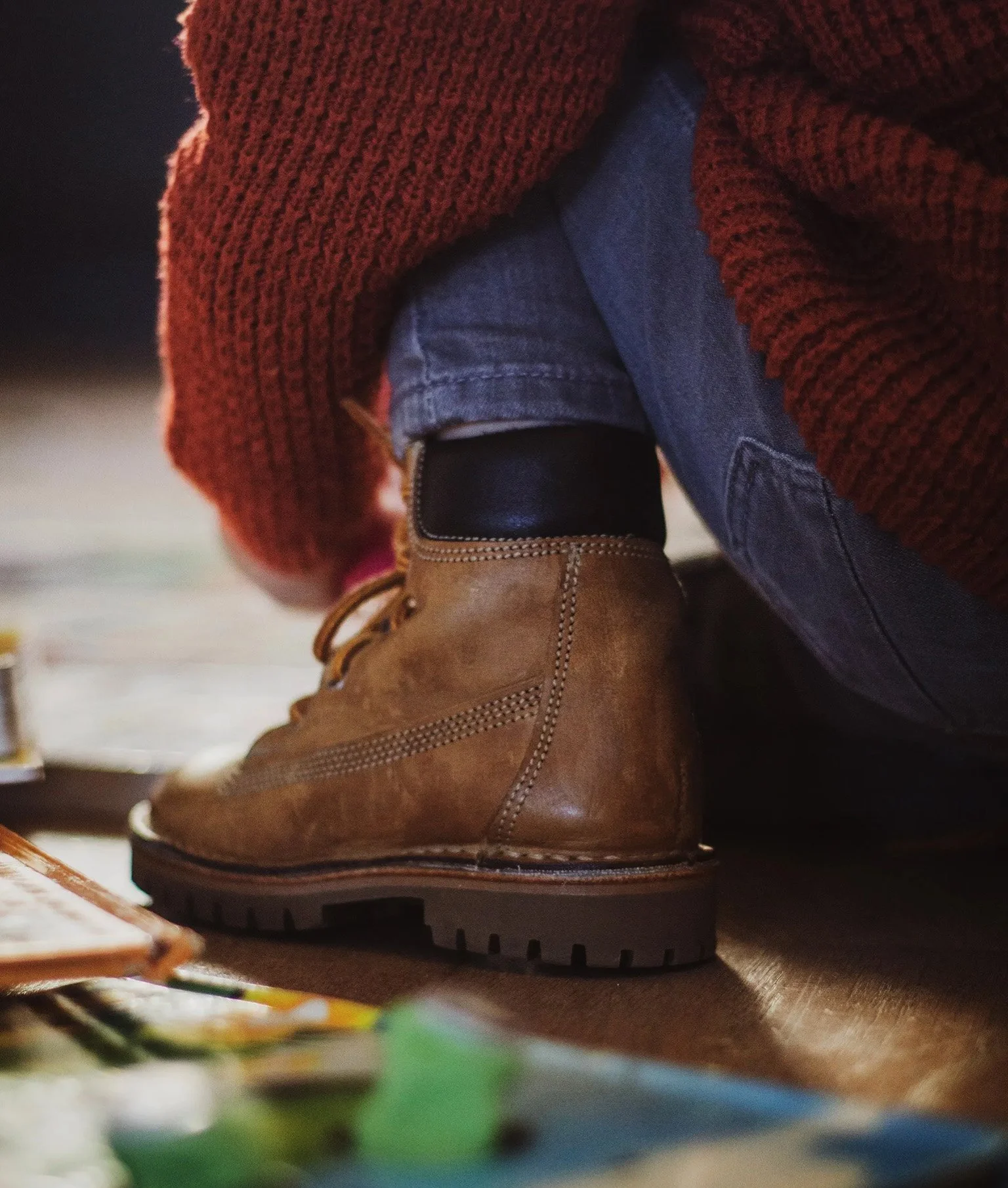 Junge trägt Lederschuh und spielt am Holzboden