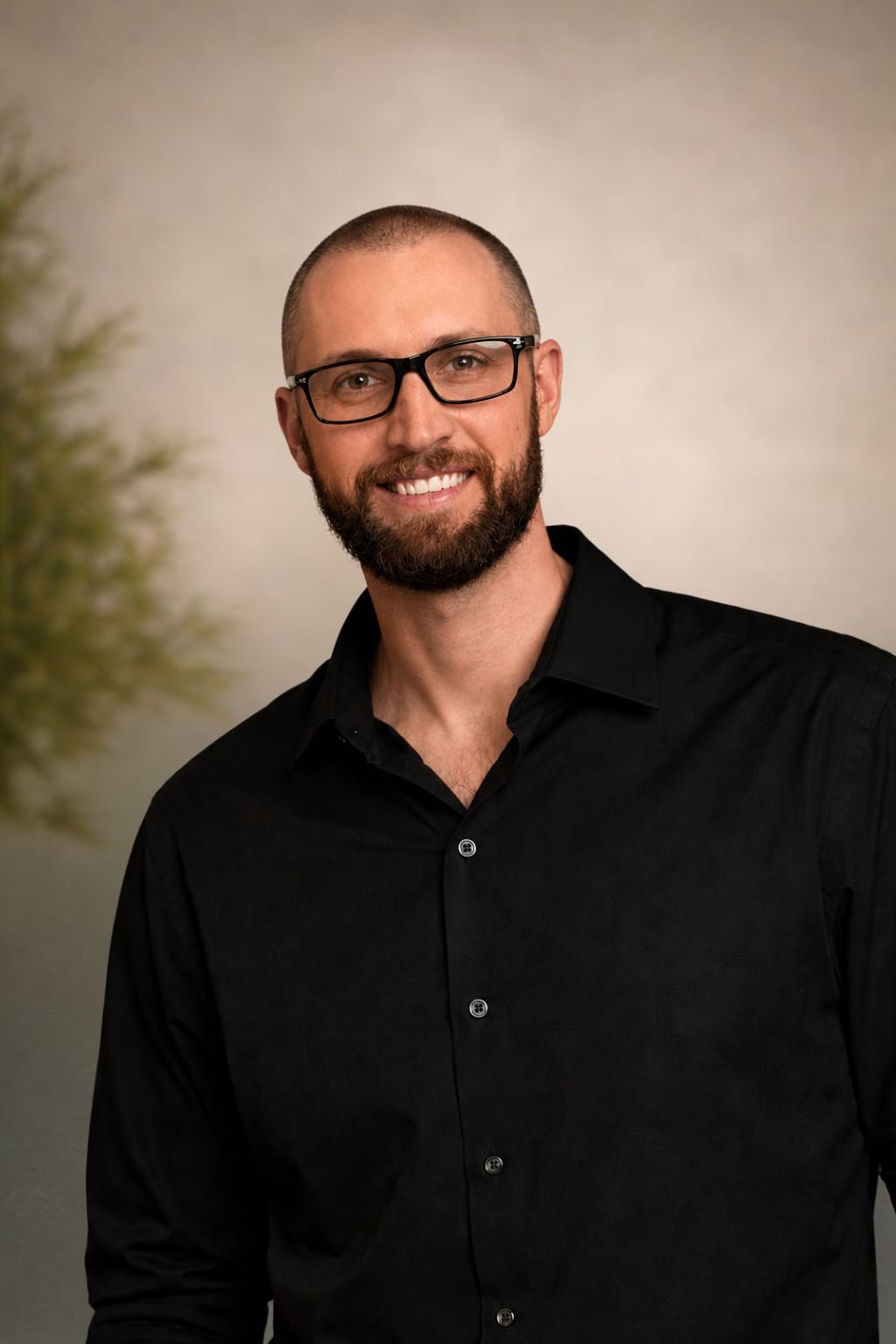Dallas, wedding and event DJ, smiling in a black button-up shirt and glasses