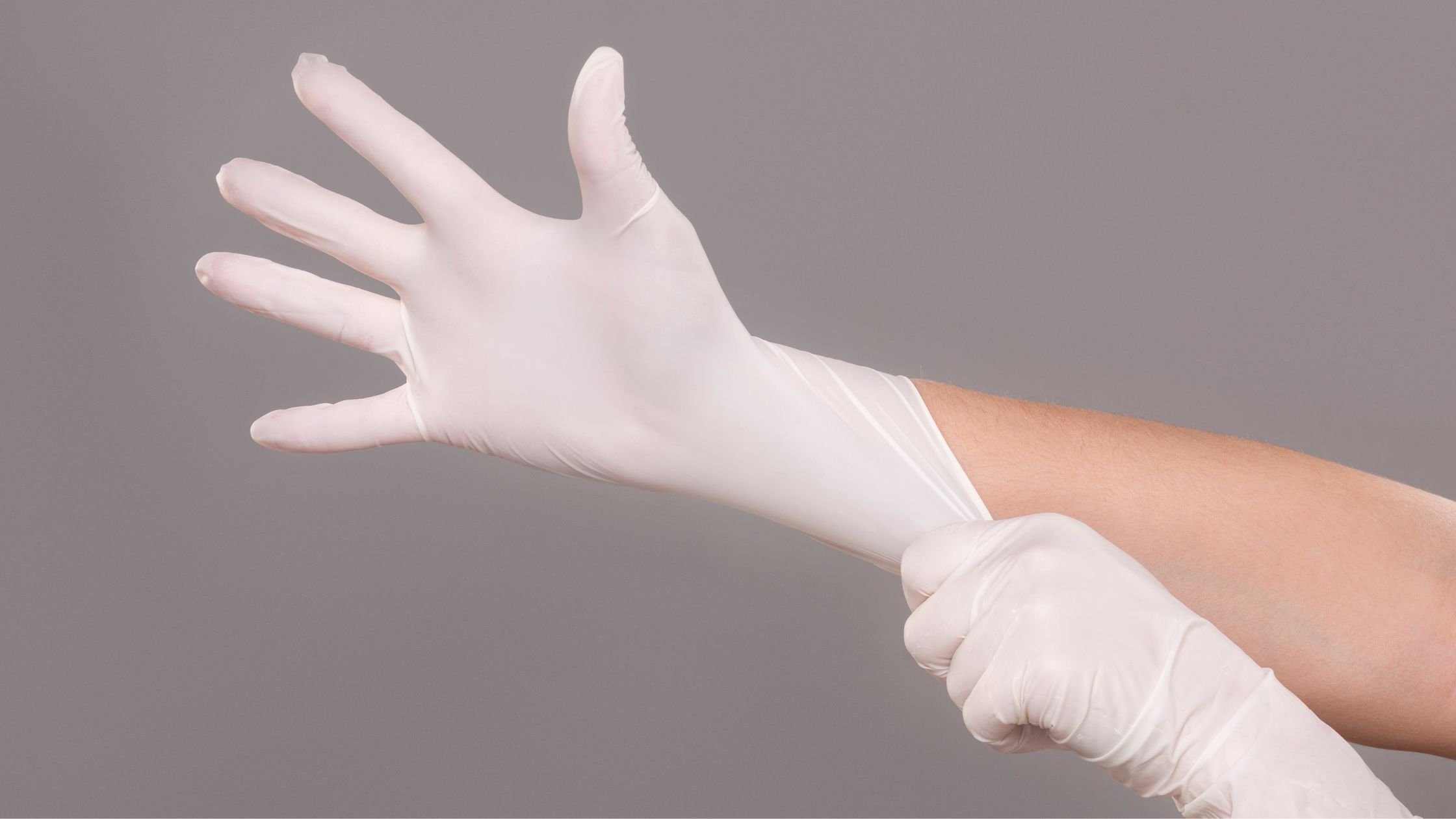 Person putting on white disposable gloves for a beauty procedure