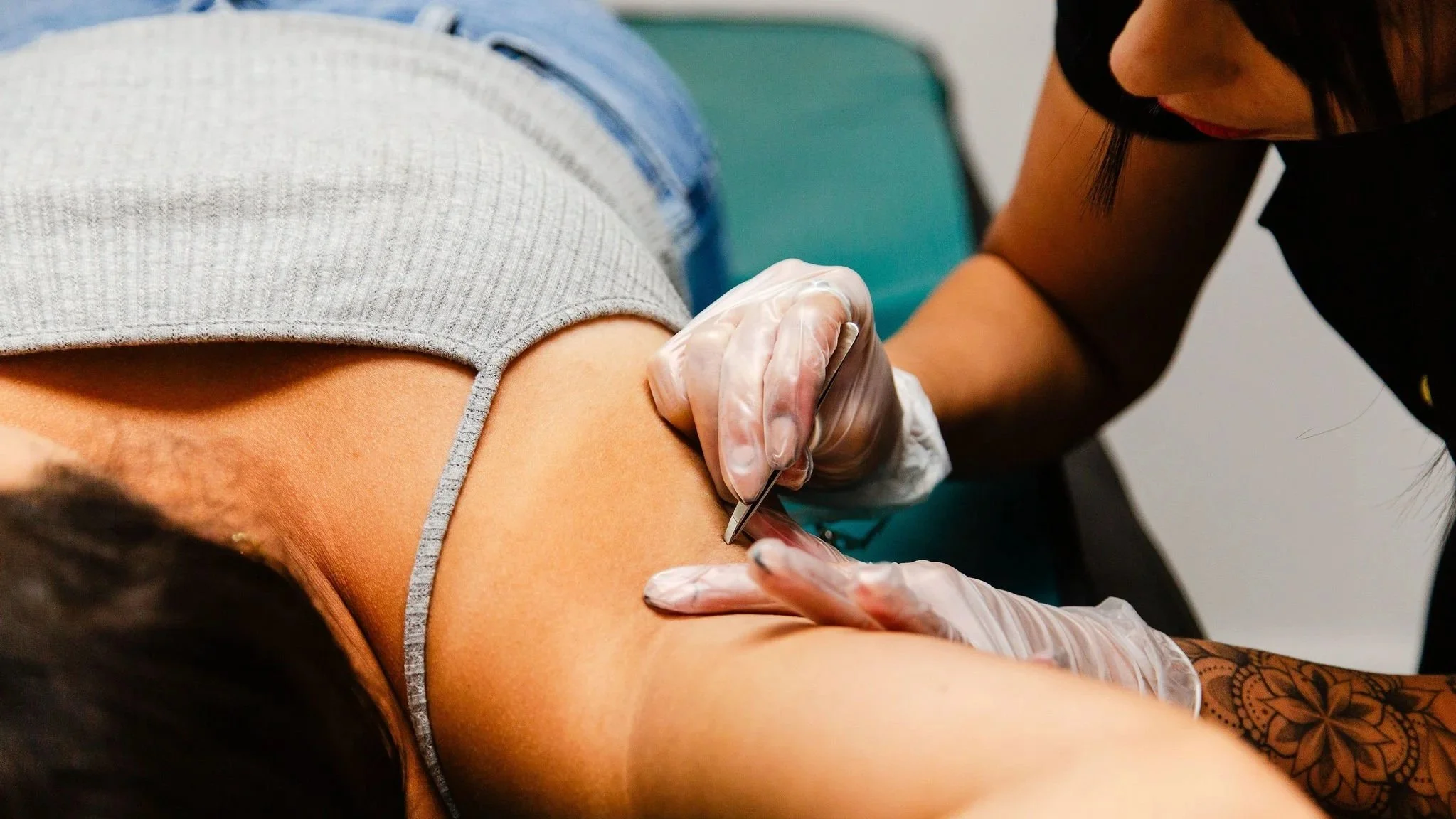 : Waxing professional performing a treatment on a client’s skin