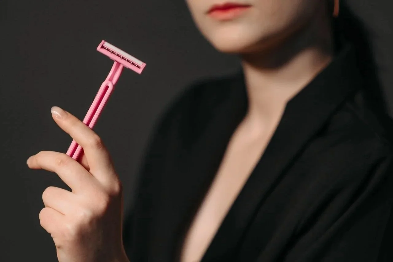 Woman holding a razor against her hand