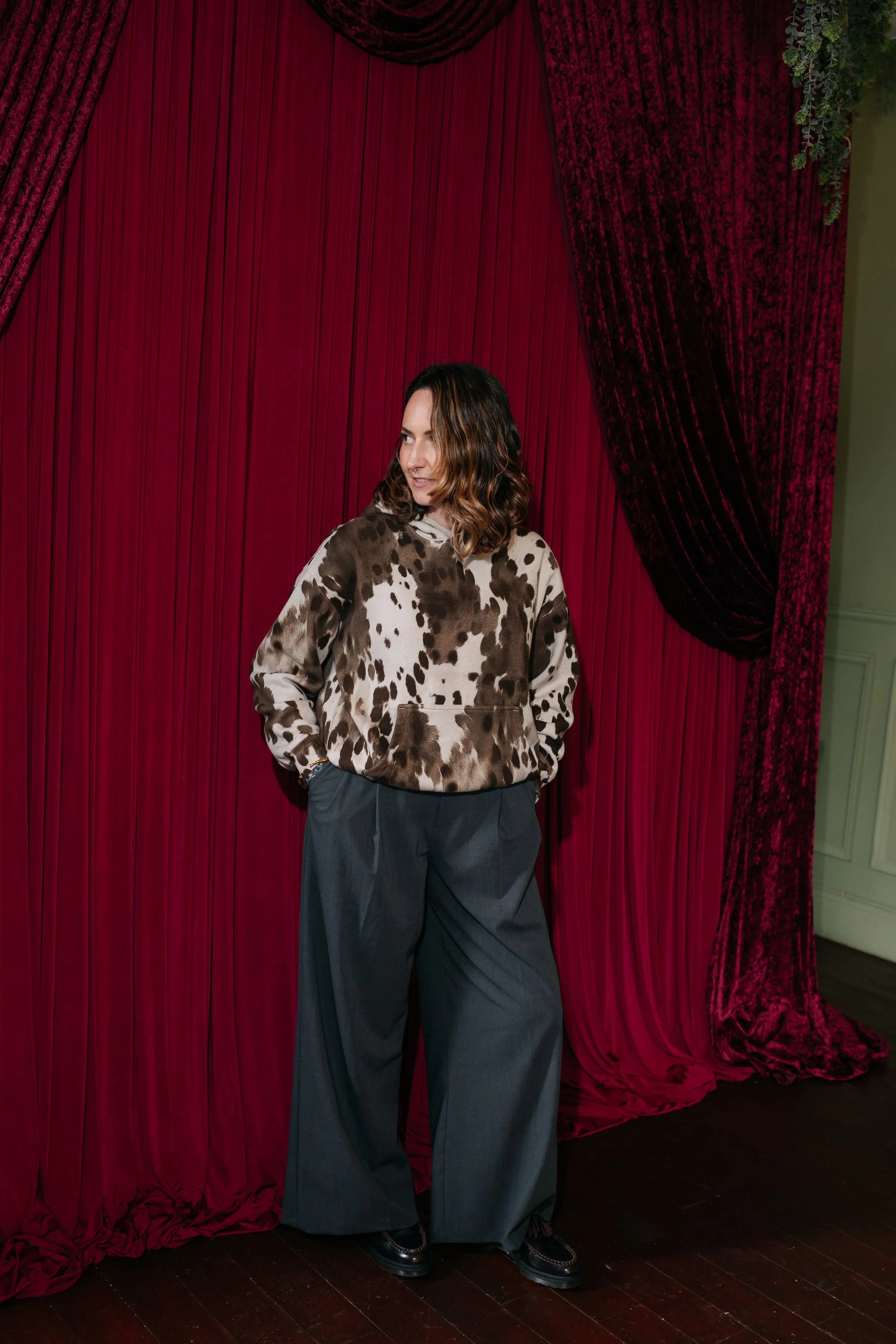 Jenni, the owner of Cherry on pop standing in front of red velvet drapes. Styled alternative wedding stylist by Cherry on Pop in Lanarkshire