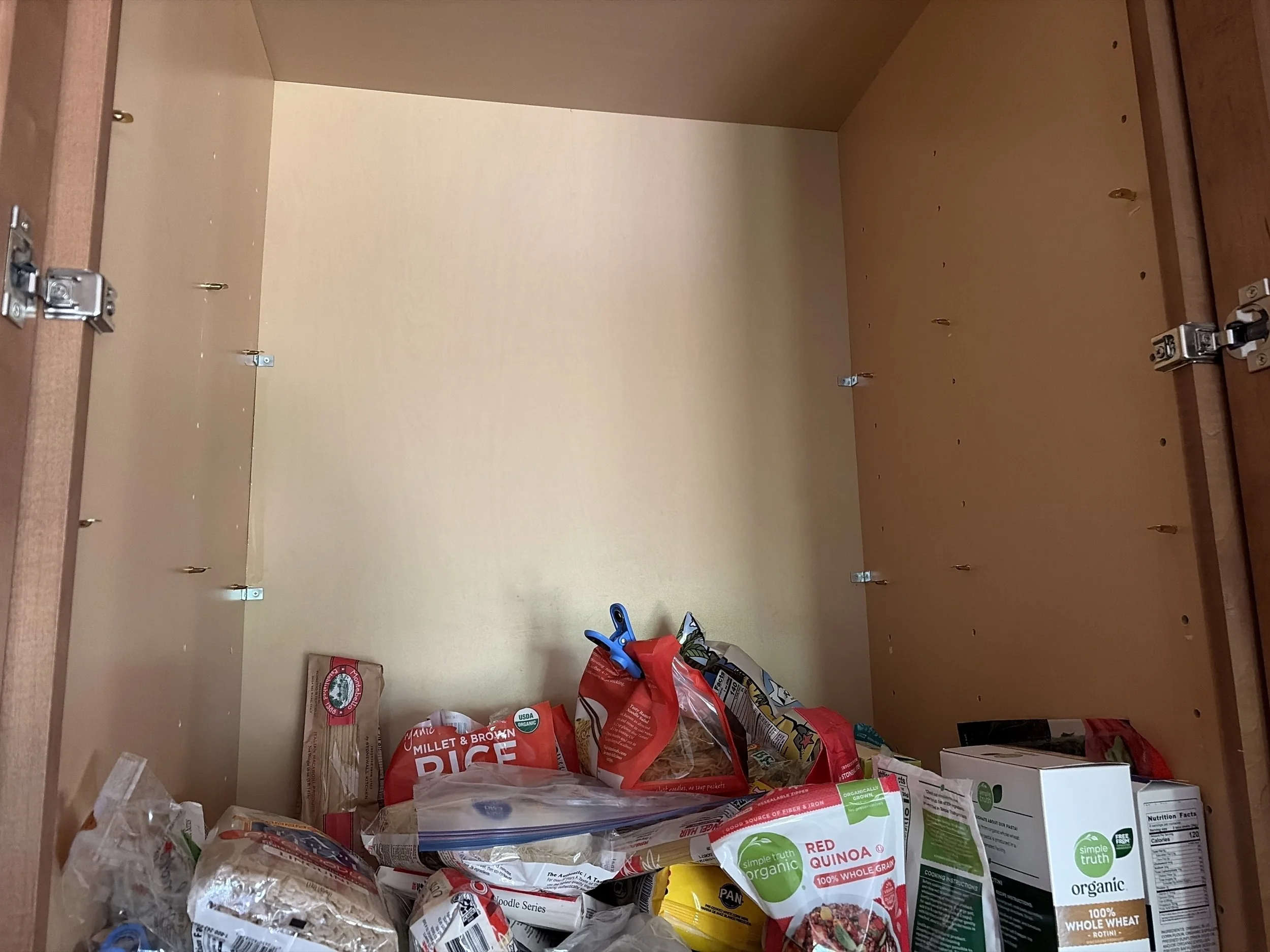 Close-up of a repaired pantry cabinet corner joint with L-bracket reinforcement and stronger shelf pins installed, Lafayette Colorado kitchen cabinet repair