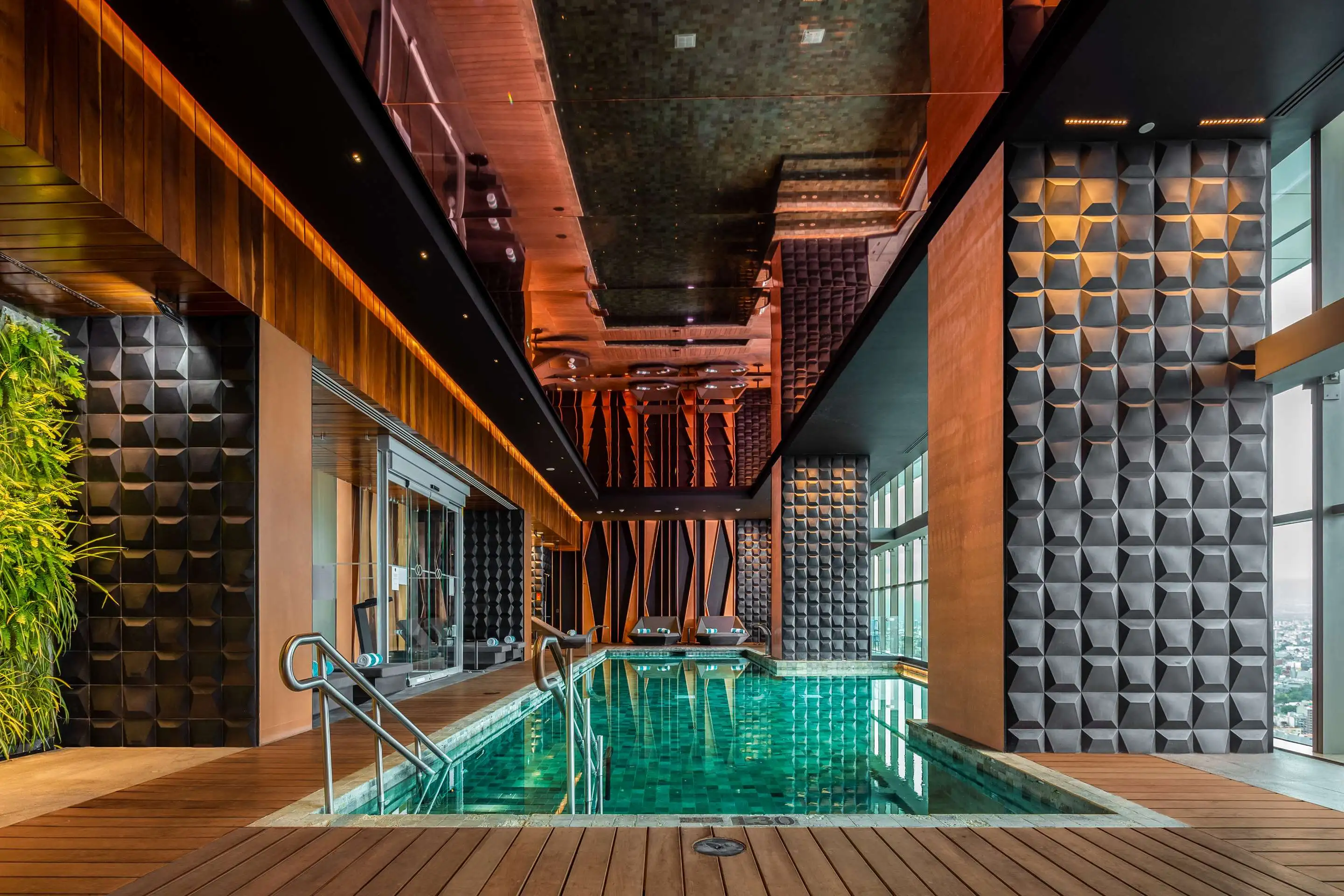 Indoor swimming pool area with wooden floors, decorative wall panels, large windows with city view, and a modern ceiling design.
