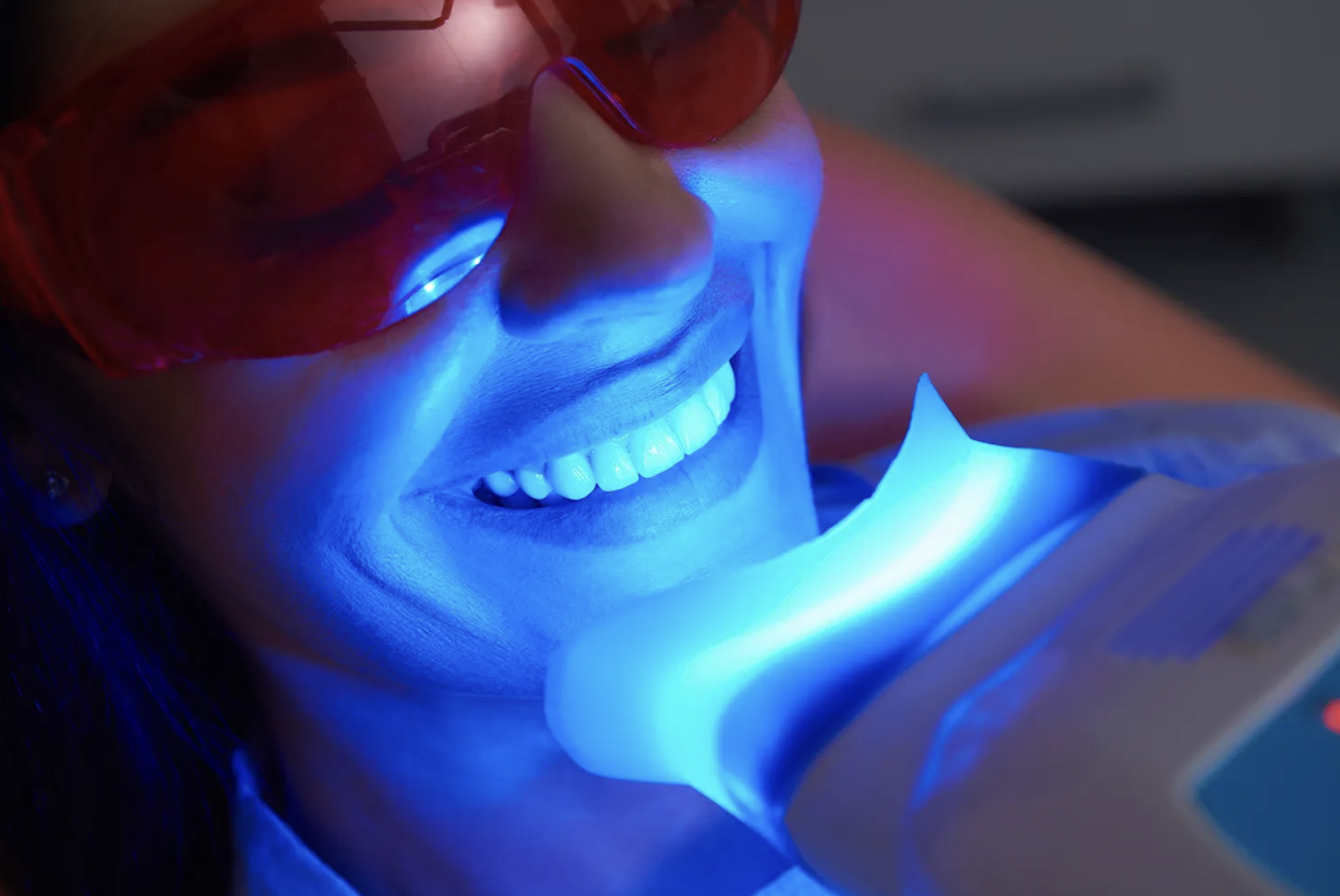 Smiling client wearing protective glasses during a professional LED teeth whitening treatment at A2 Wellness in Las Vegas