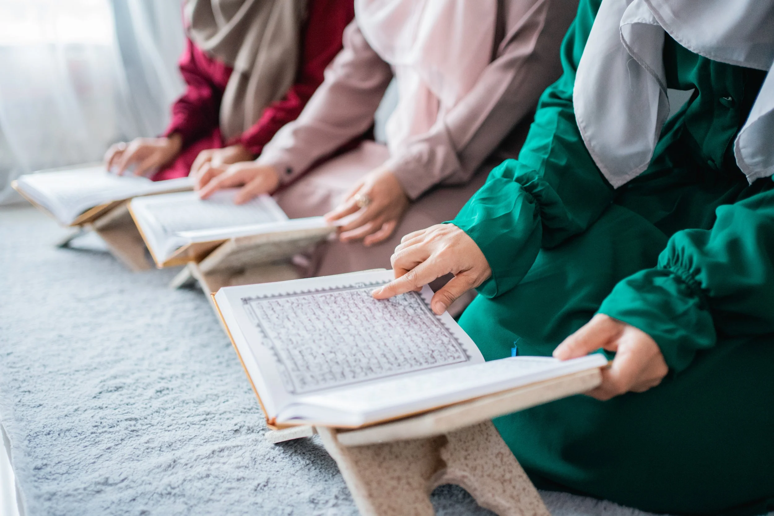 three-young-women-wearing-hijabs-read-holy-book-al-quran-together.jpg