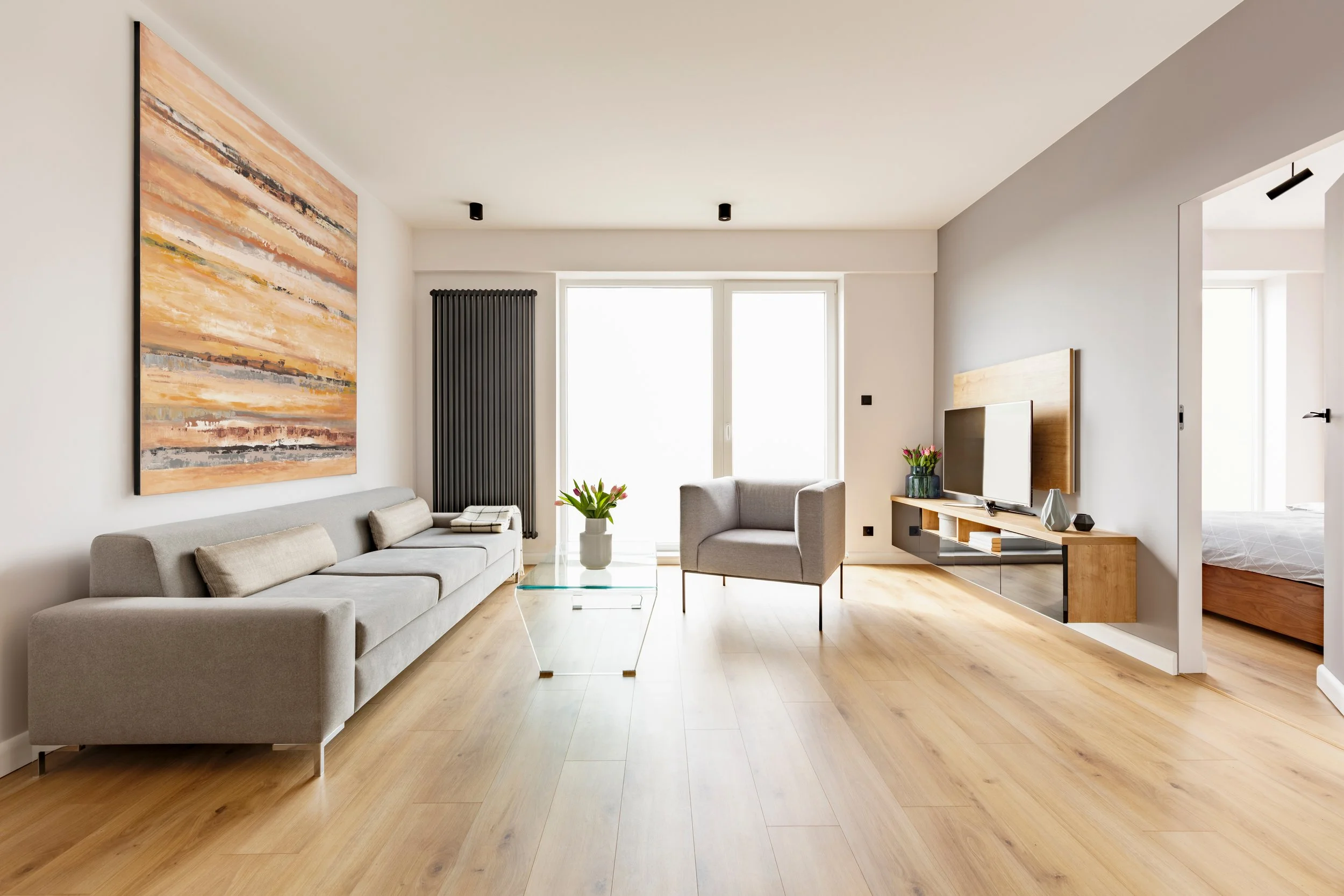 Image of a large open living room with plenty of natural light color drenched in an off-white paint.