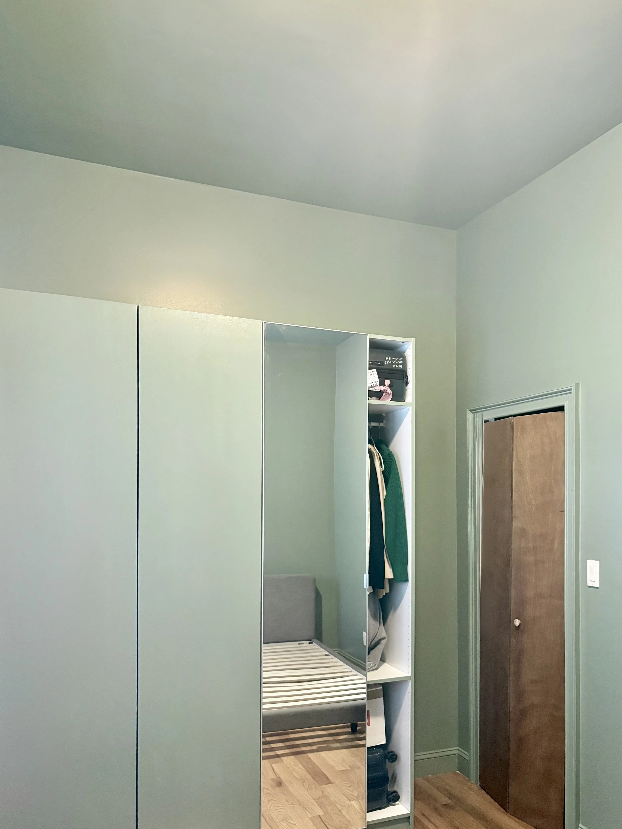 Image of a color drenched bedroom in a lighter shade of green