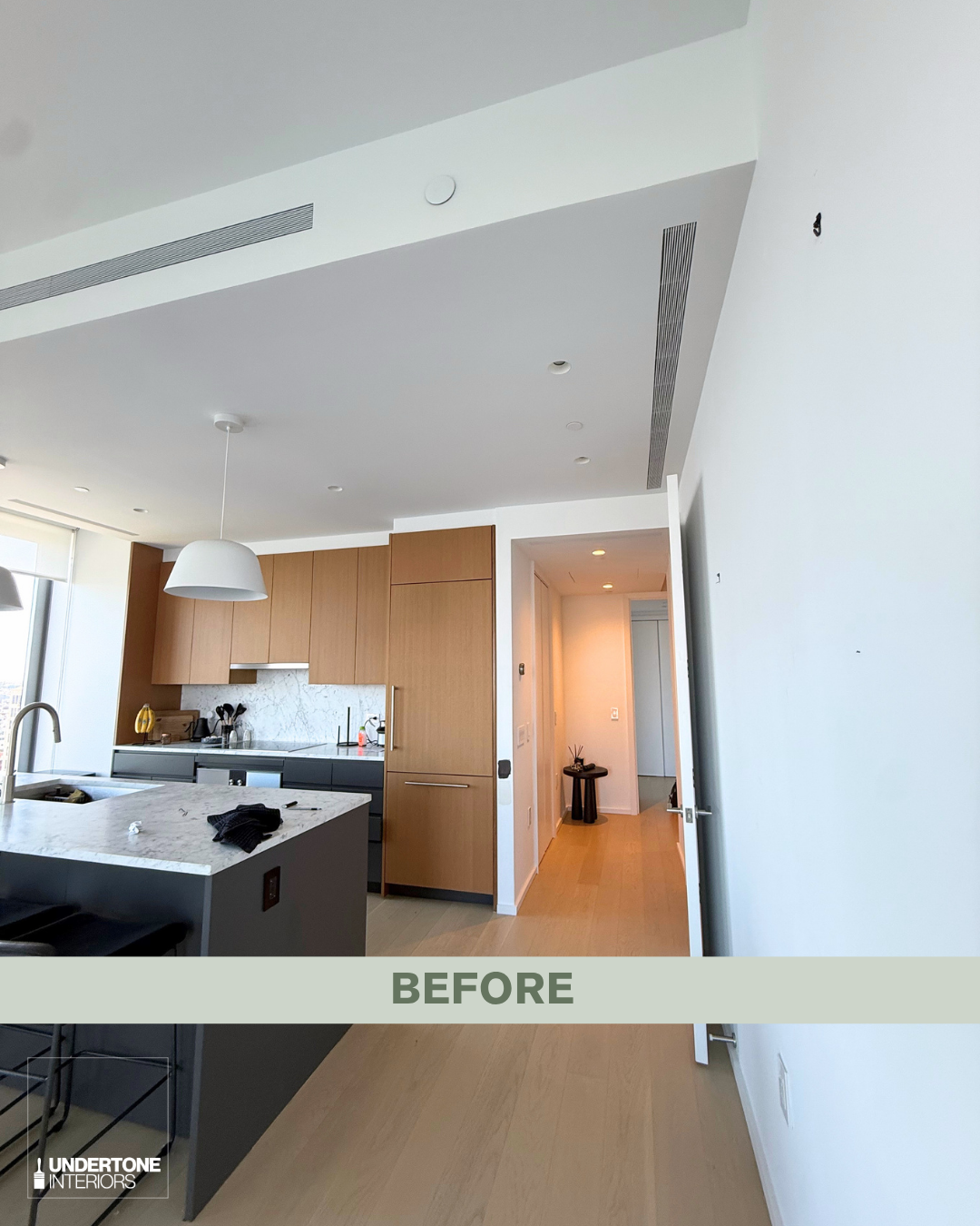 Before photo of an unpainted NYC luxury high rise condo apartment with white walls and a mix of light and dark wood cabinetry and flooring