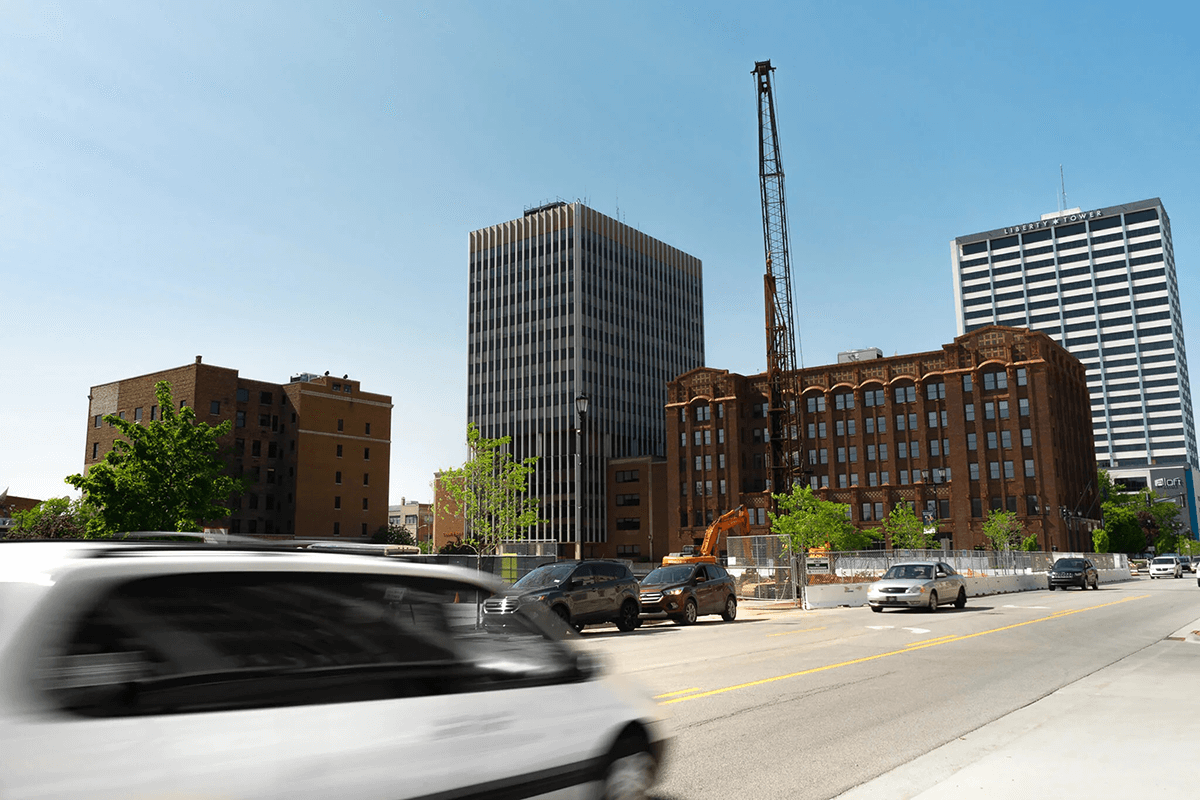 cars driving on street in front of buildings
