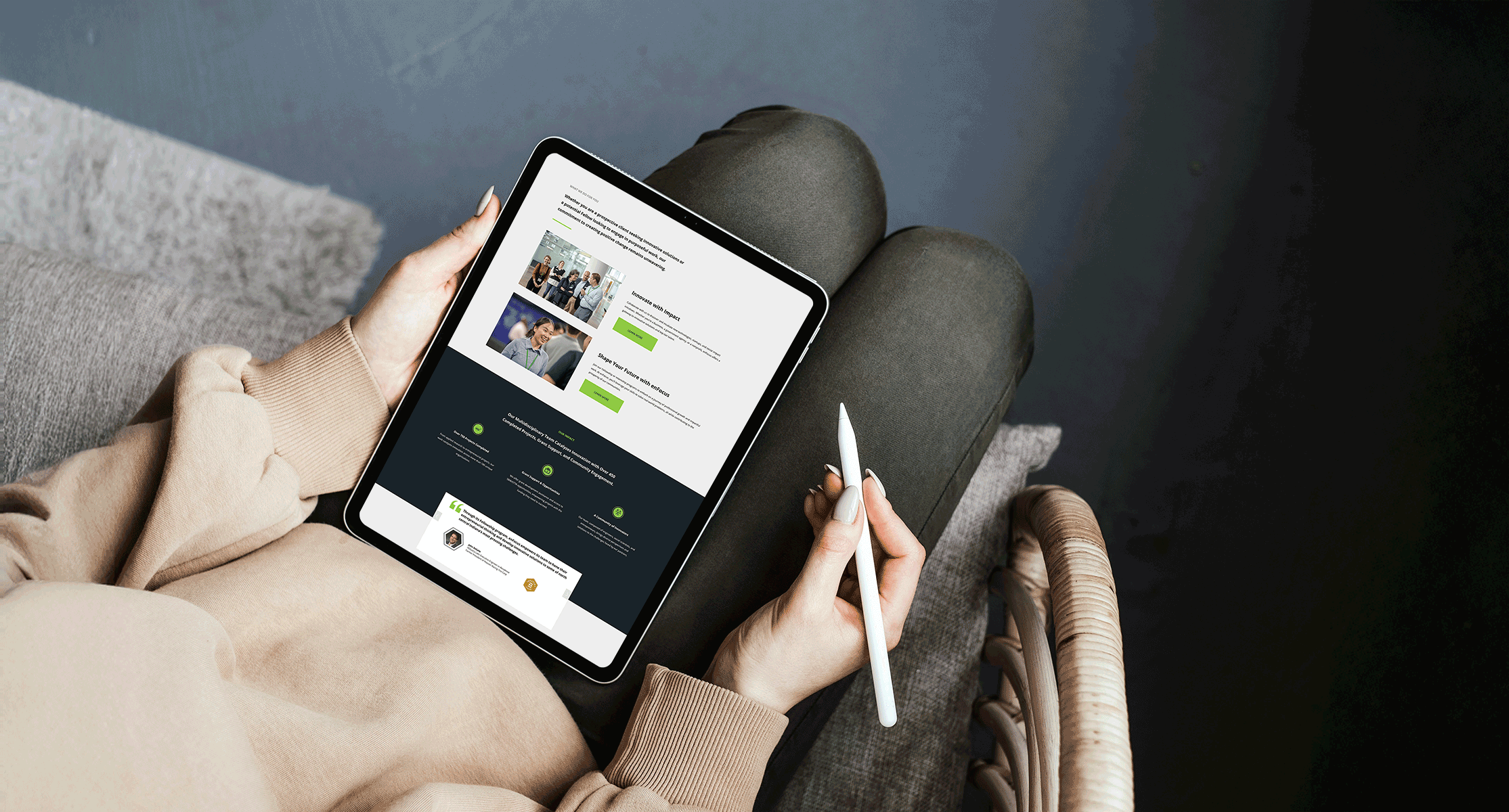 woman holding a tablet and pen with a screenshot of part of EnFocus's homepage