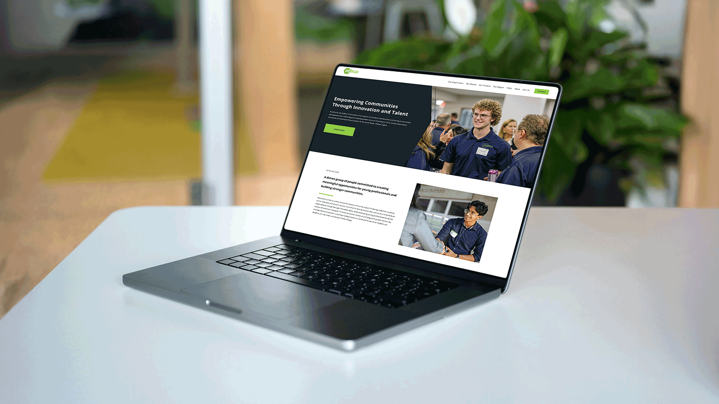 laptop sitting in office setting on white table showing a screenshot of enFocus homepage