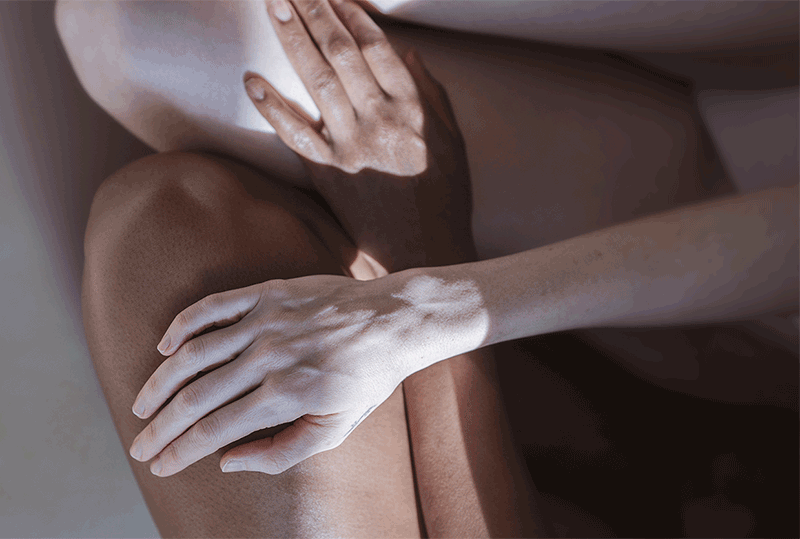 two hands with light and dark skin tones laying on top of one another