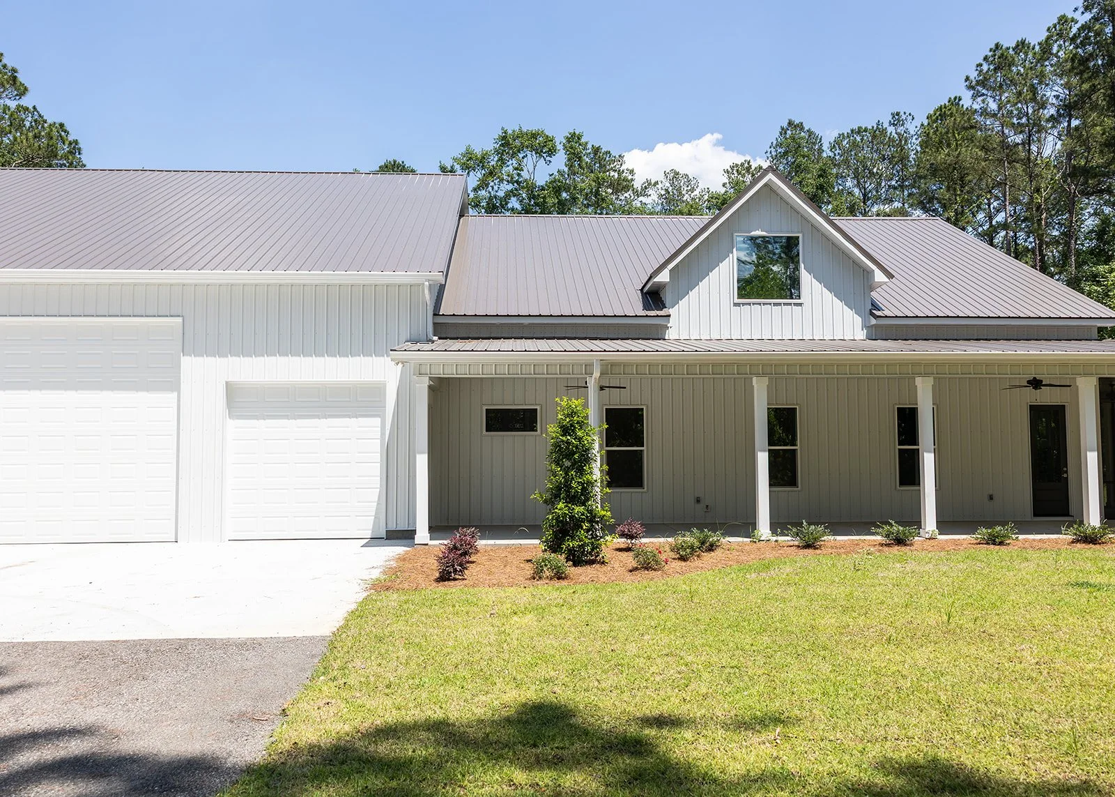Set among the pines in Guyton, this home blends modern farmhouse character with the durability of metal siding and a metal roof. A deep covered porch wraps the home in classic Southern style, with a screened porch for enjoying the outdoors year-round