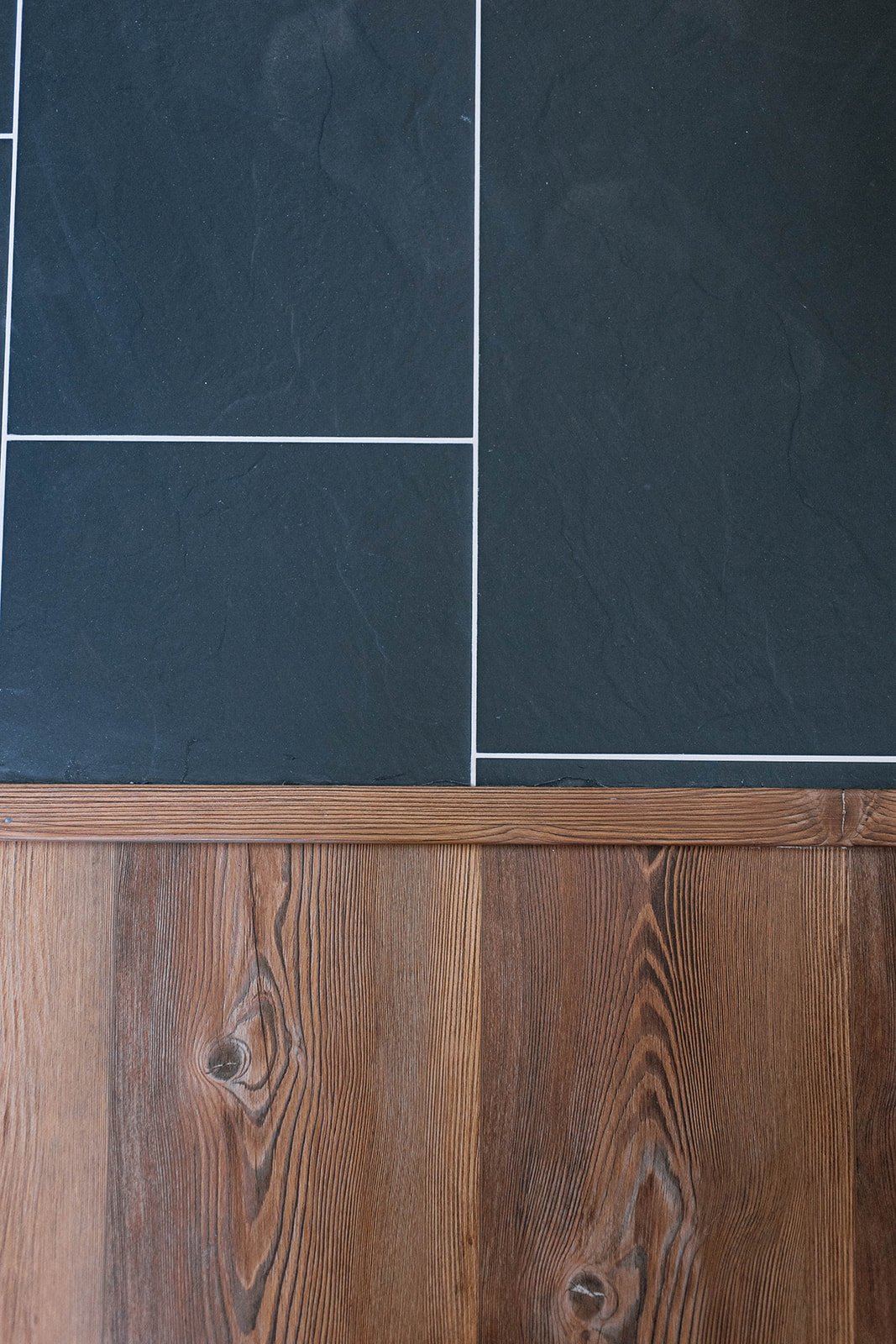 The floor transition between the master bathroom black tile and master bedroom LVP floors.