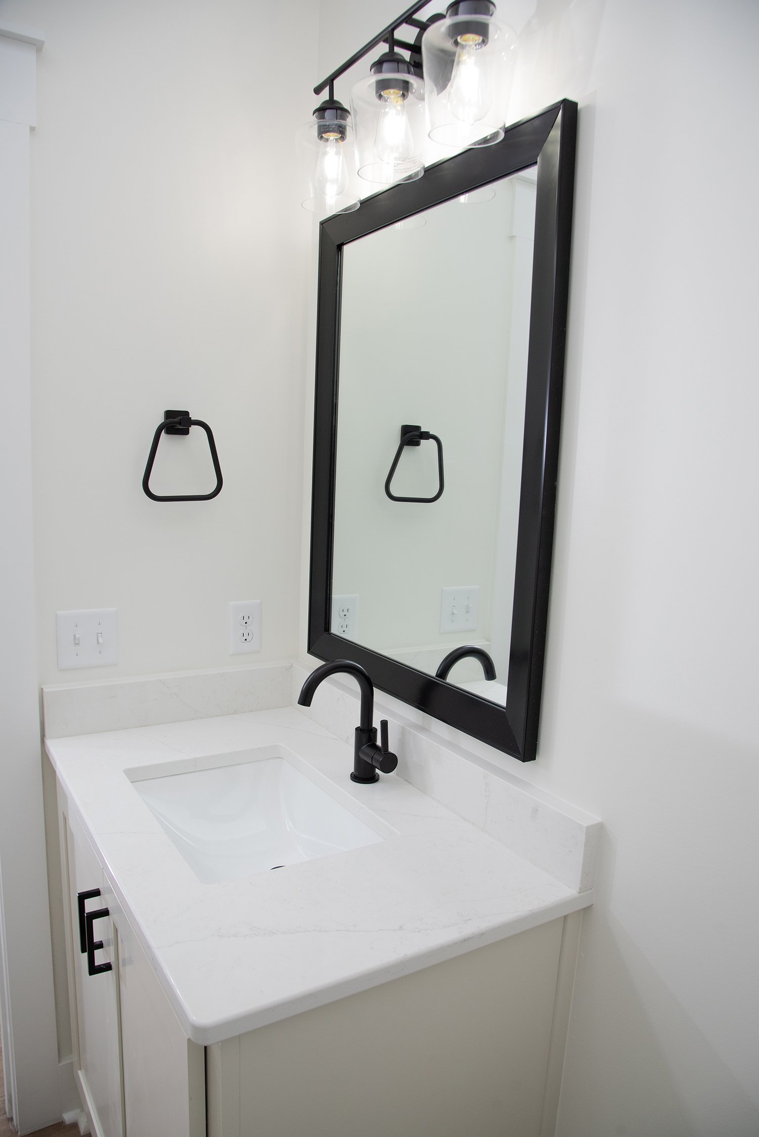 Powder bathroom with custom built vanity cabinet and black finishes.