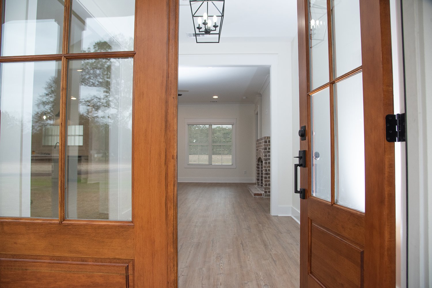 Entrance to this low-country style farmhouse with stained Golden Oak door.