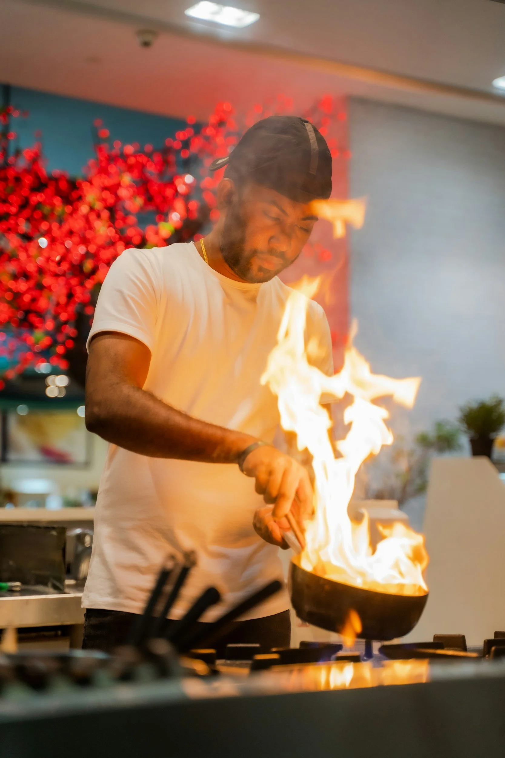 Chef cooking with flames in a pan in a kitchen