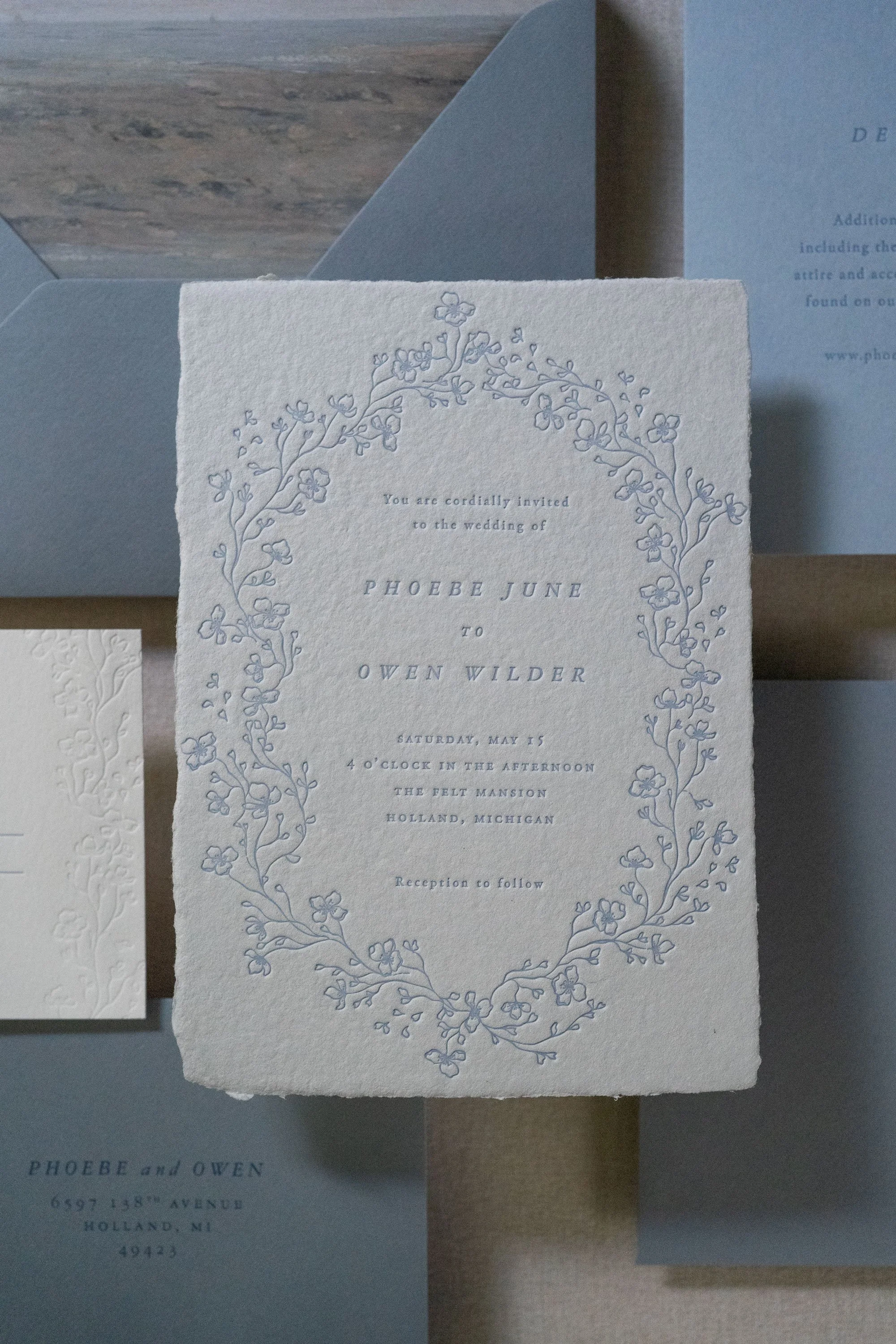 Tone-on-tone blue semi-custom letterpress wedding invitation with elegant type and floral border